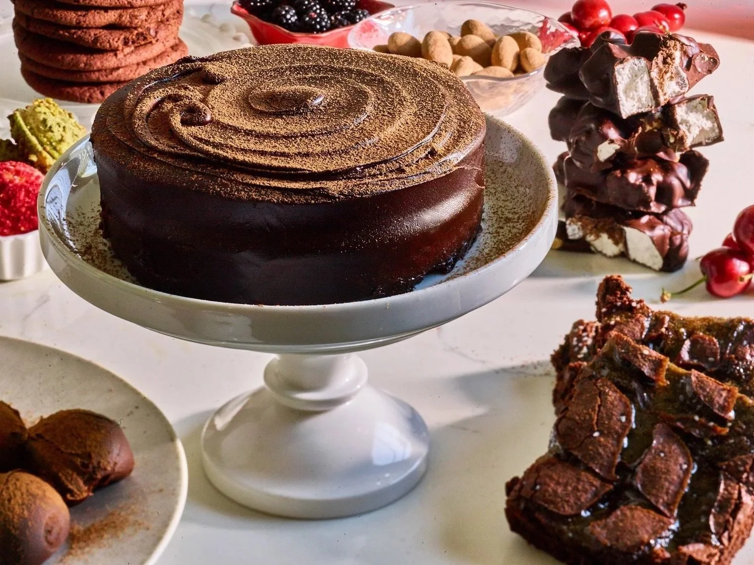 Food styling: chocolate cake on a cake stand with brownies