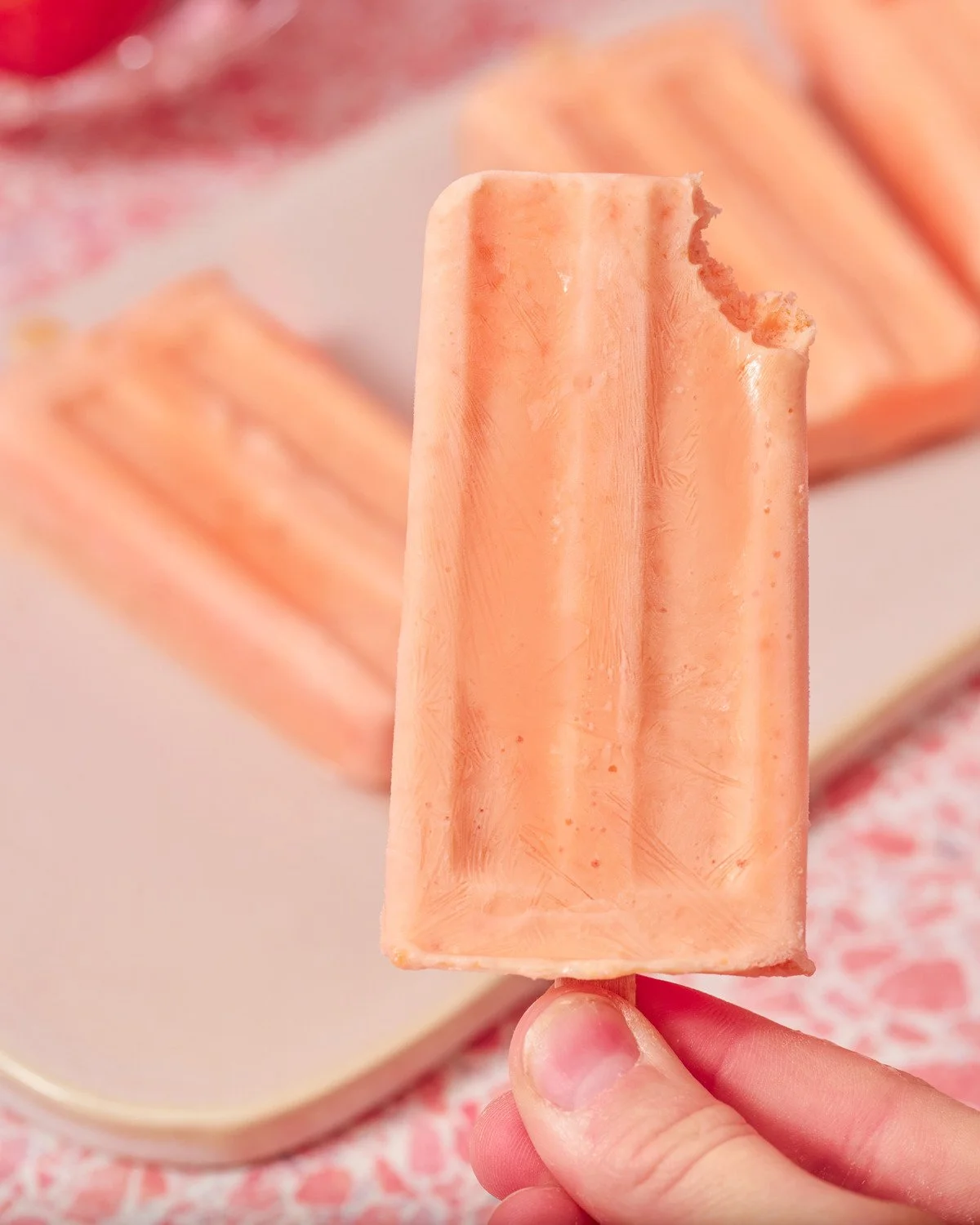 Peach yogurt popsicle on a peach background. Frozen dessert product photography.