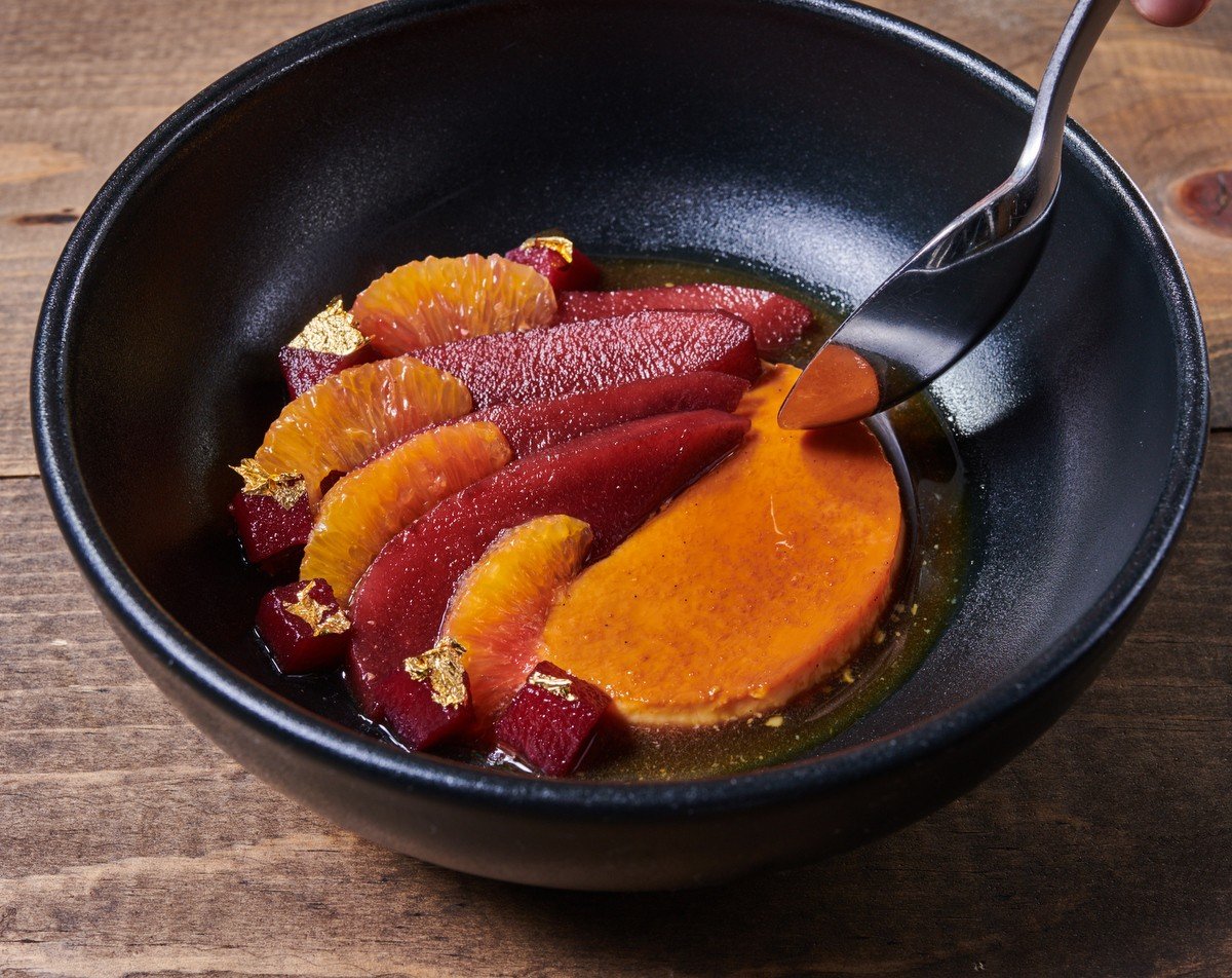 Blood orange and citrus dessert in a black bowl from the Culinary Institute of America restaurant menu