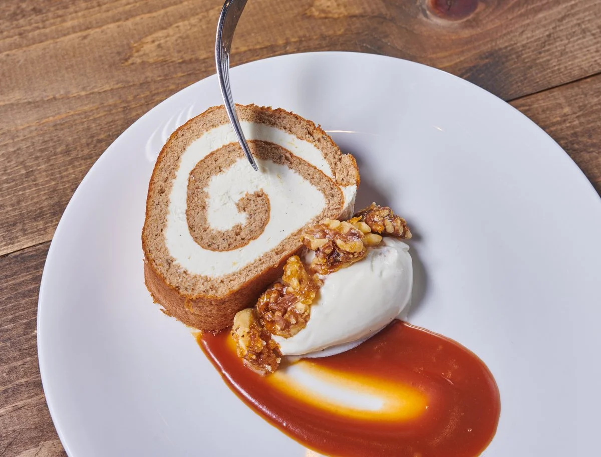 Rolled cake dessert with caramel sauce and cream