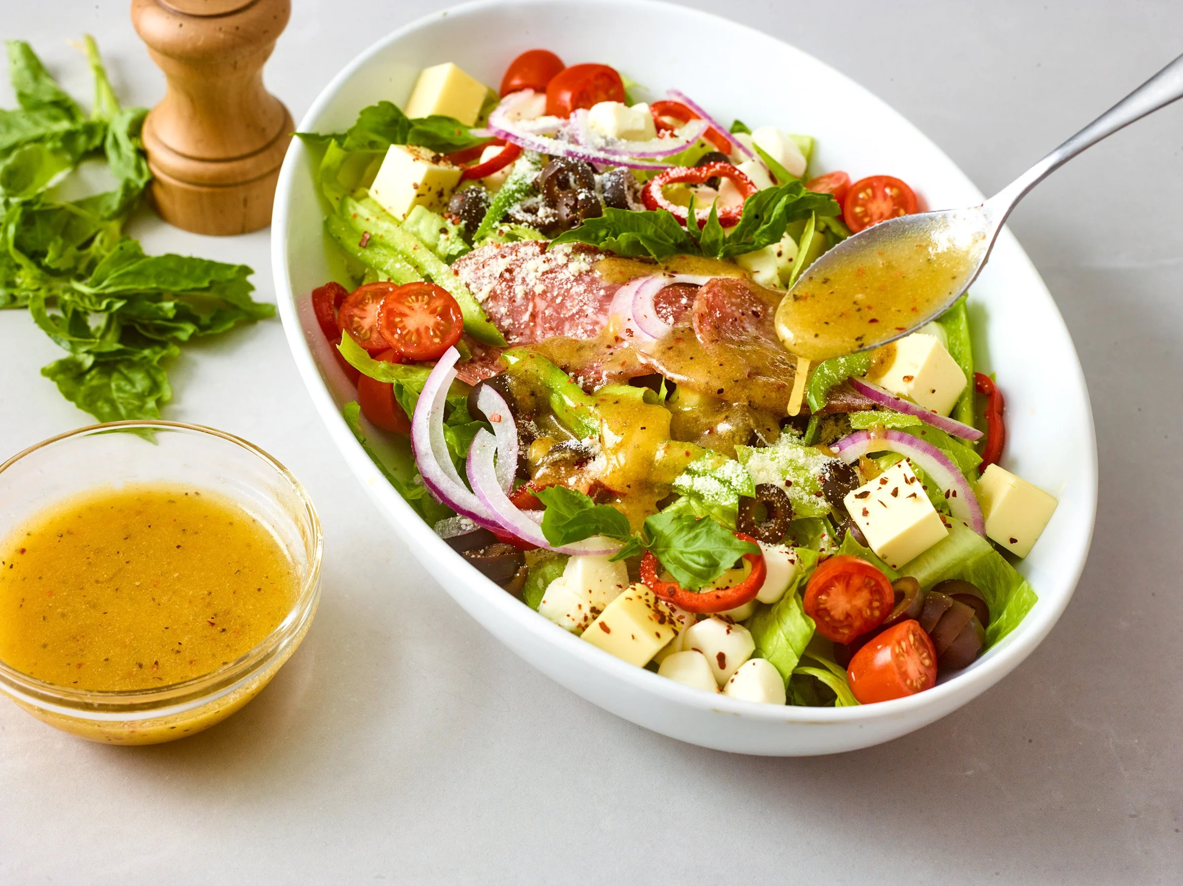 Food styling: antipasto salad with Italian dressing pour