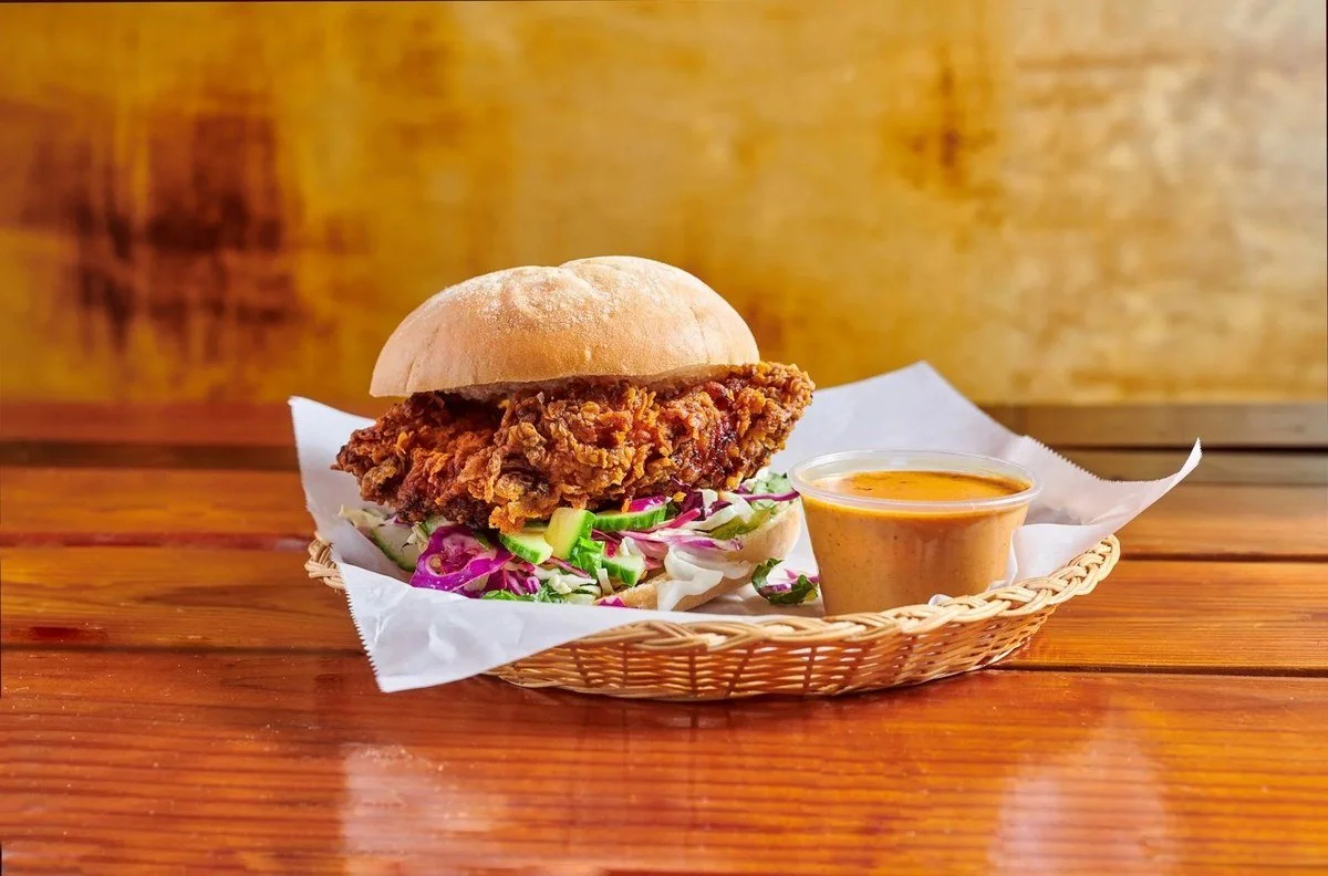 Fried chicken sandwich in a basket with sauce
