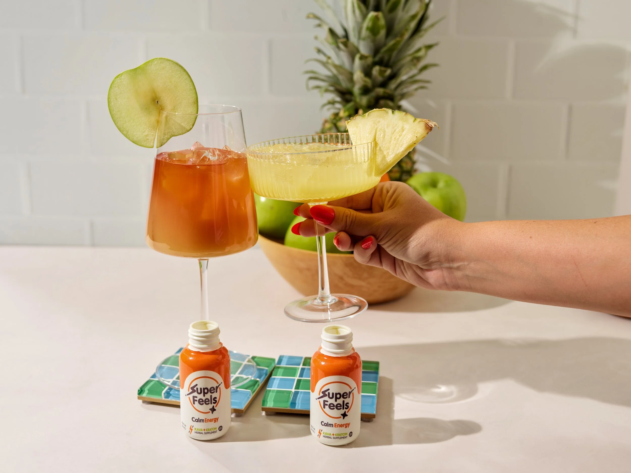 Super Feels wellness shot poured over ice with tropical fruit