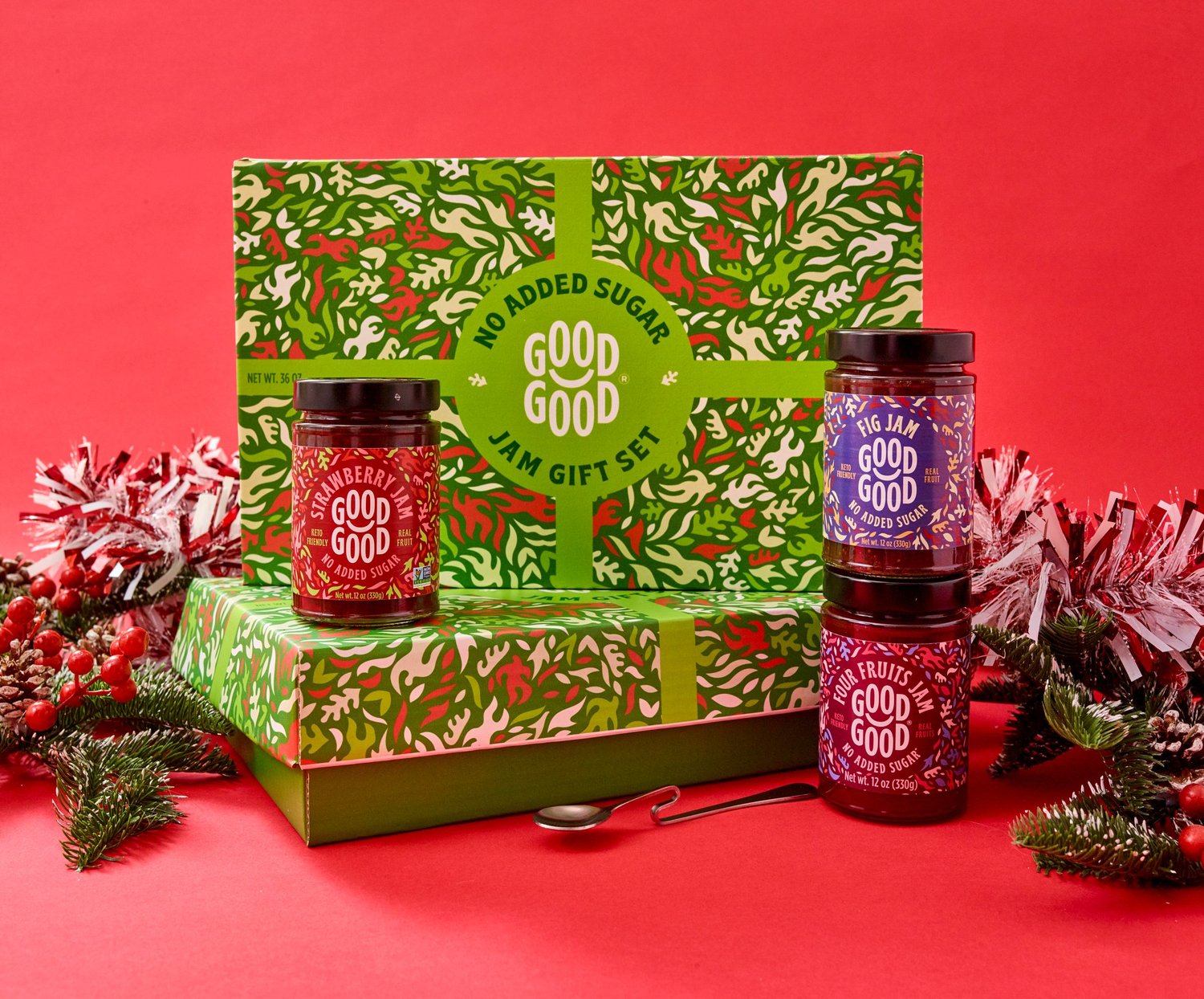 Holiday gift set styled on a red set with greenery, product photography