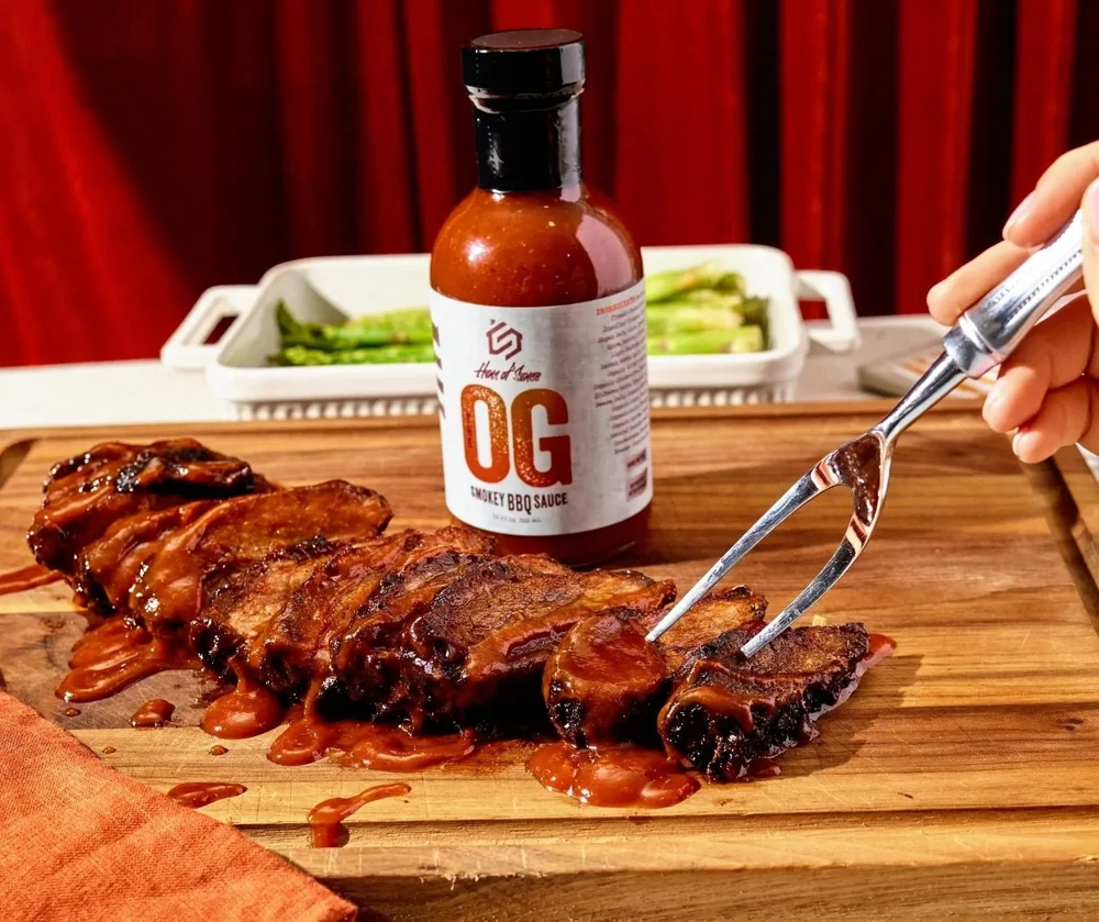 Hero of Sauce The OG BBQ sauce with ribs being carved, CPG sauce photography