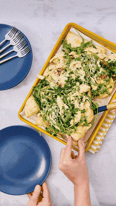 Stop motion GIF of a pierogi sheet pan dinner served with arugula. Animated frozen food recipe content.