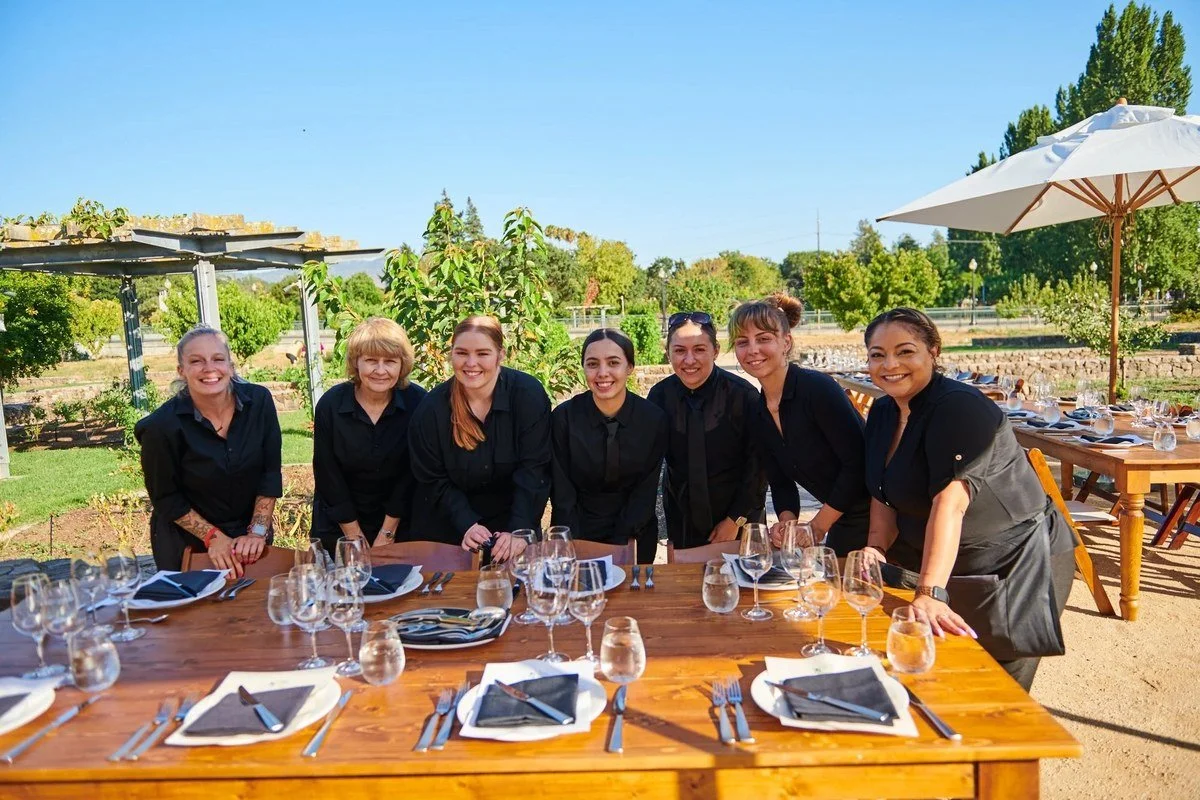 Restaurant staff at a long farm-to-table setting