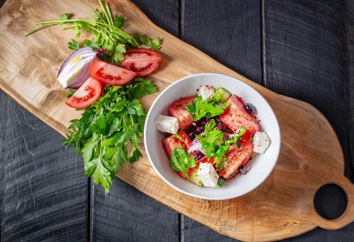 Greek salad bowl on a wood board