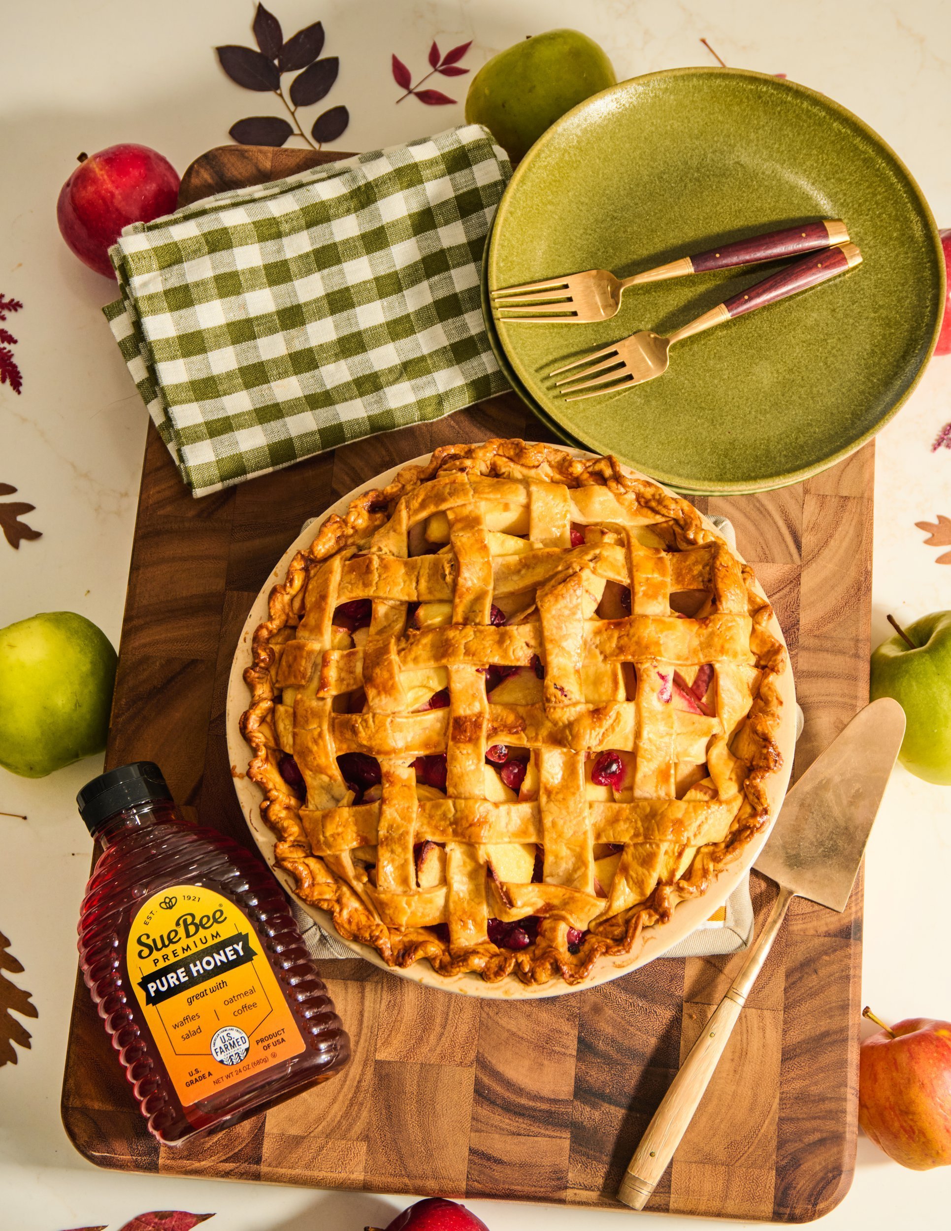 Sue Bee honey apple pie with a golden lattice crust on a fall table, natural texture and soft shadows