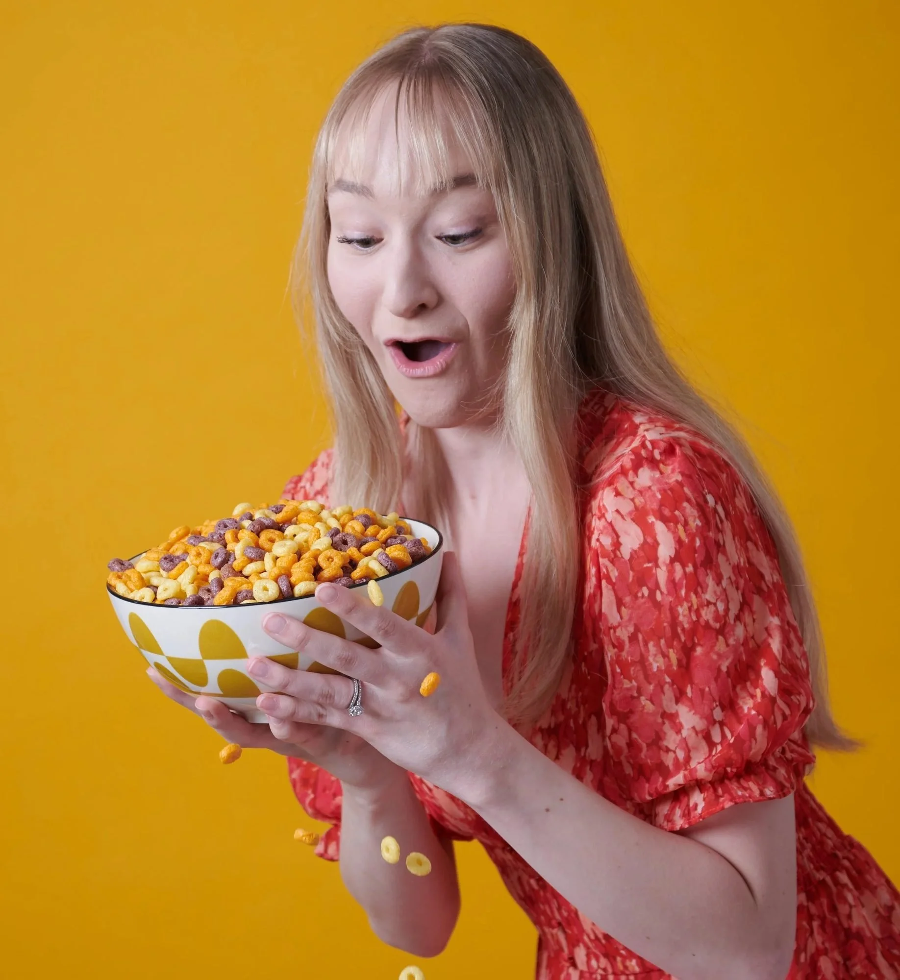 Surprised model with a bowl of popcorn on yellow, CPG snack lifestyle photography