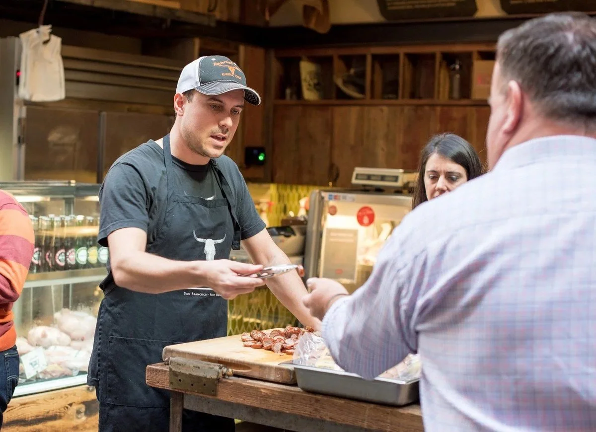 Chef handing an order to a customer at the counter
