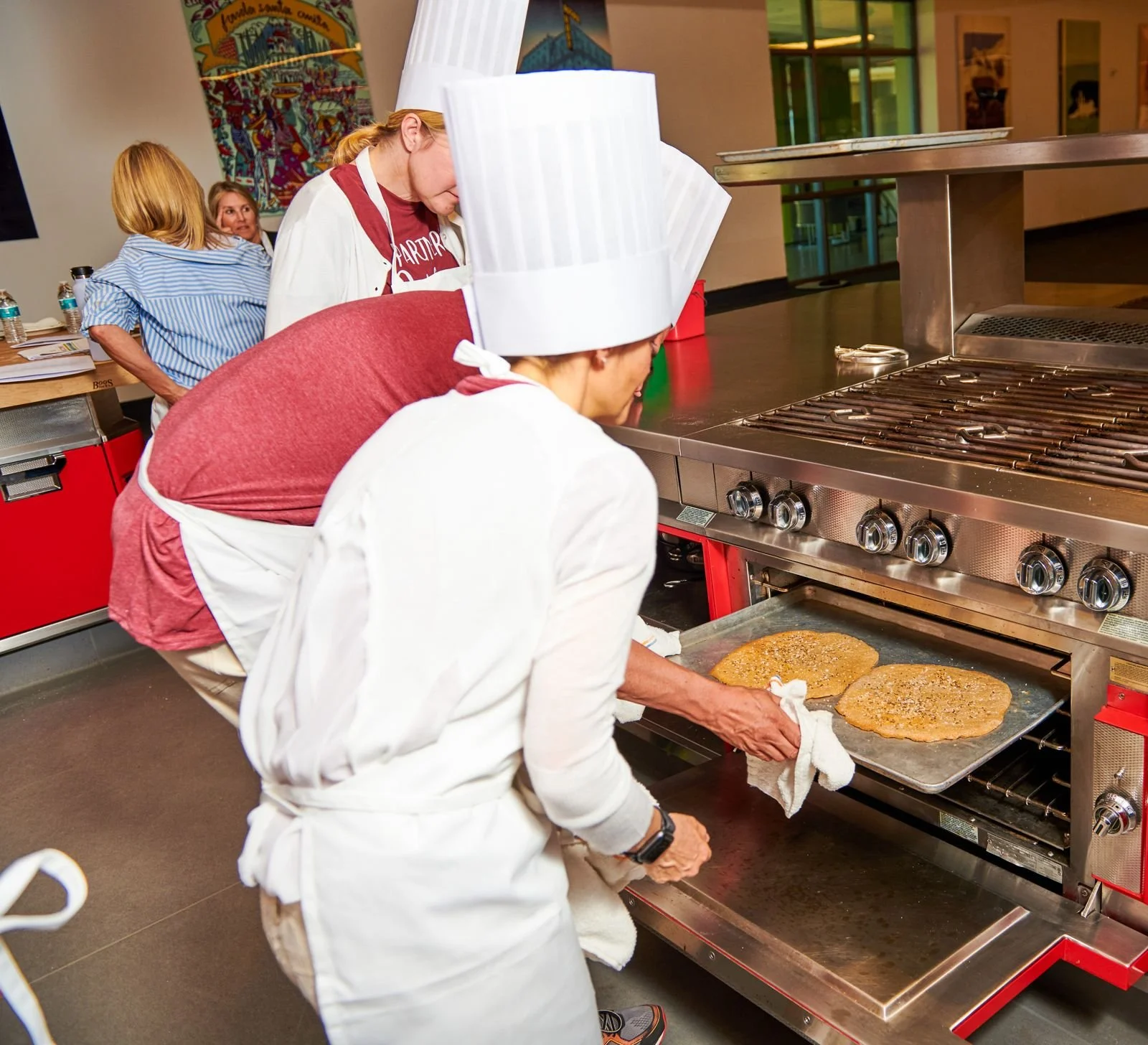 Chef in a toque working at the oven in a CIA kitchen