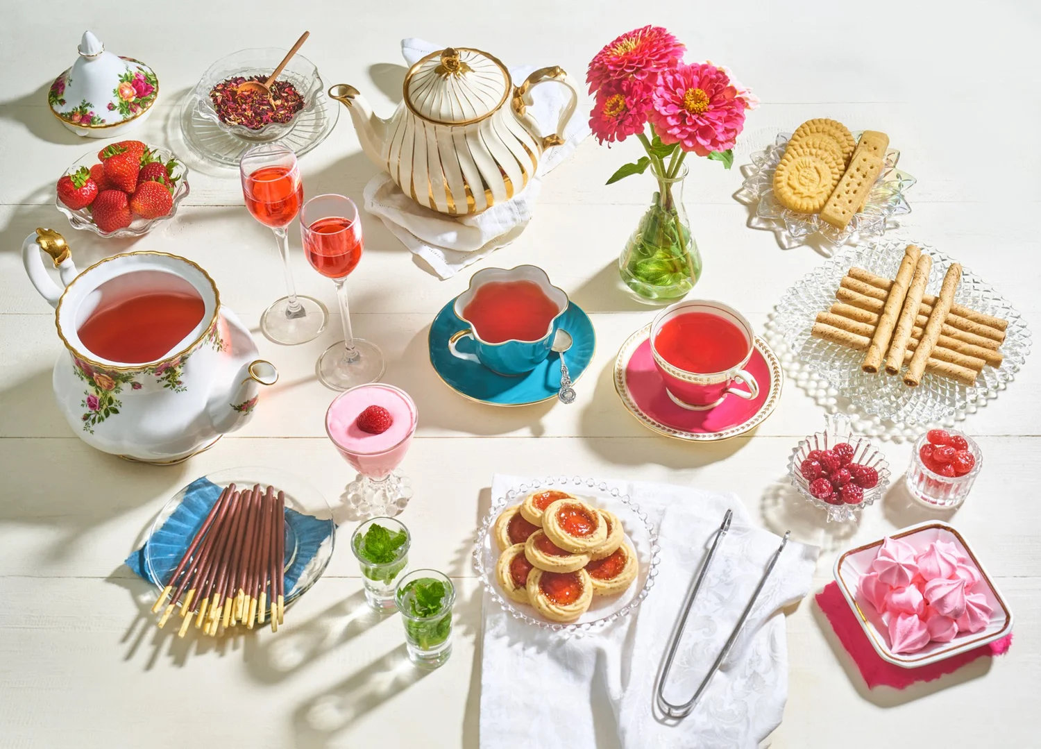 Tea party spread with teapots, cups and treats
