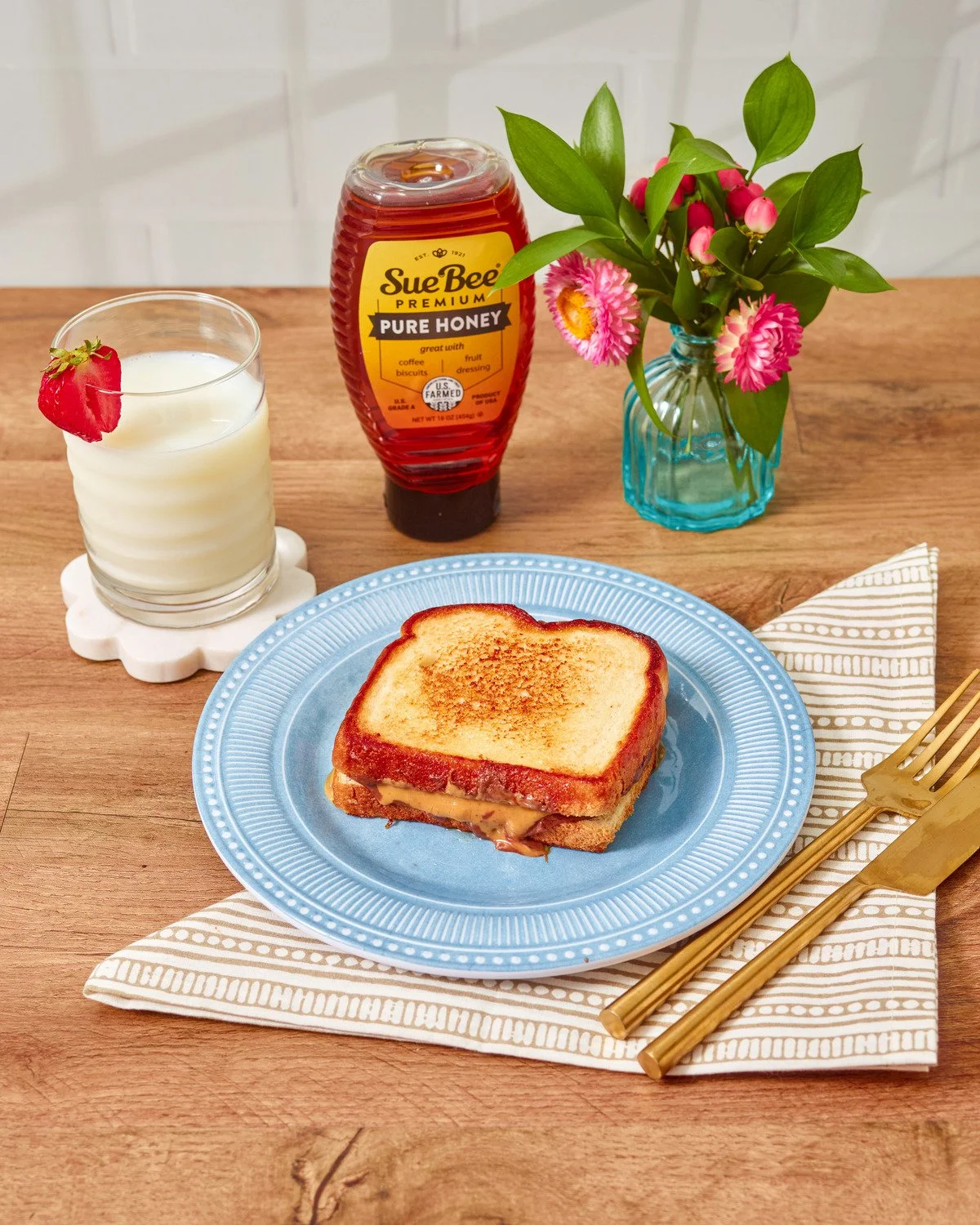 Grilled cheese sandwich drizzled with Sue Bee honey with milk. Comfort food recipe photography for a honey brand.