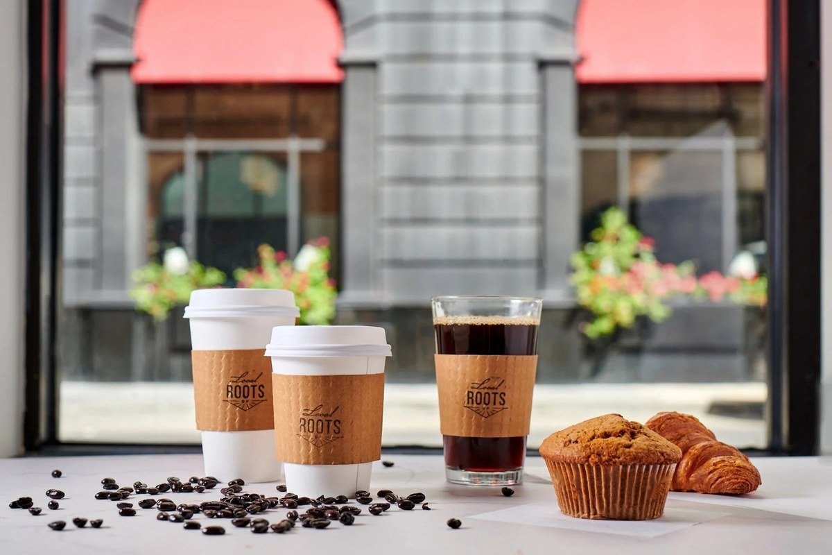 Coffee cups and a muffin in a cafe window