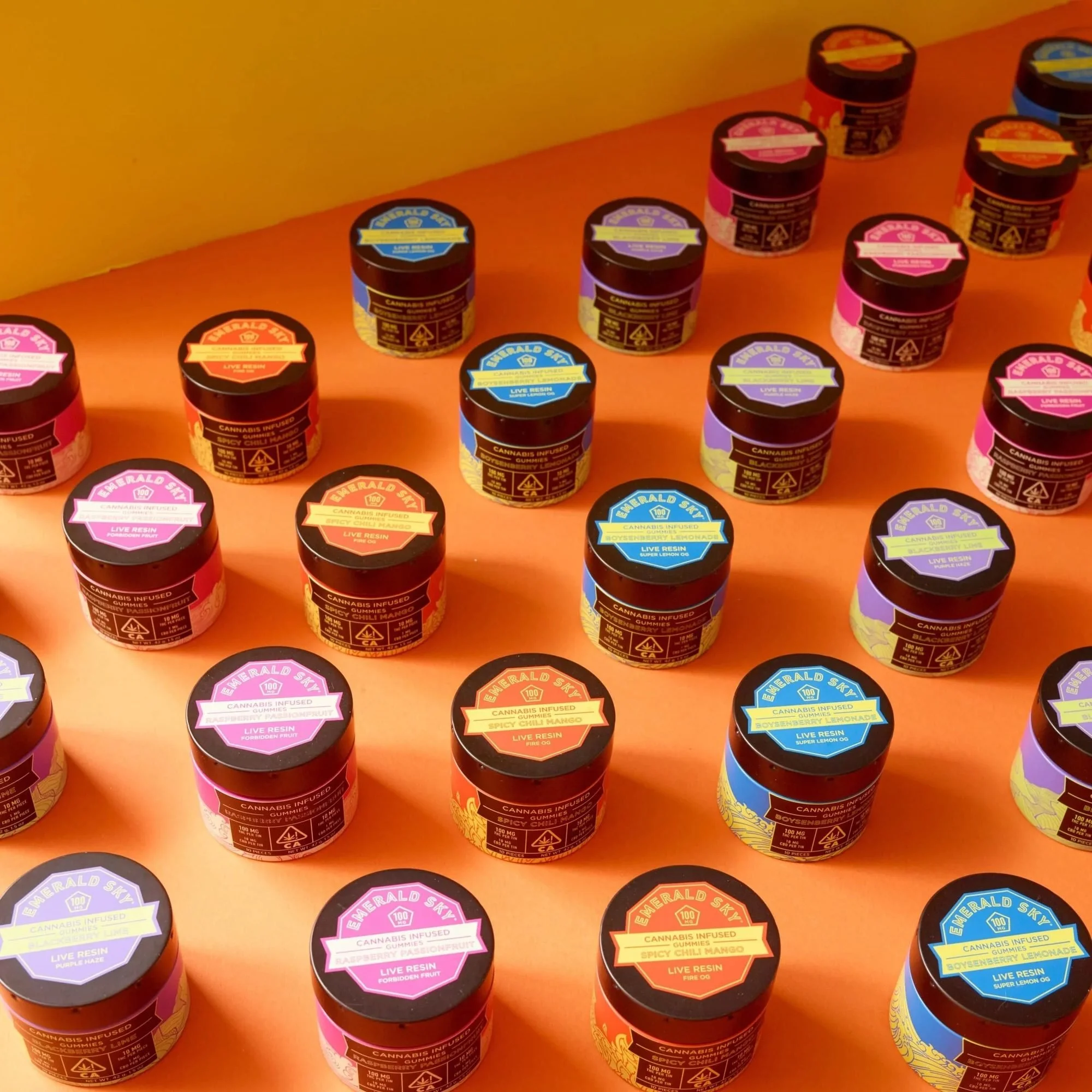 Pattern of jars with colorful lids on orange, creative CPG packaging photography