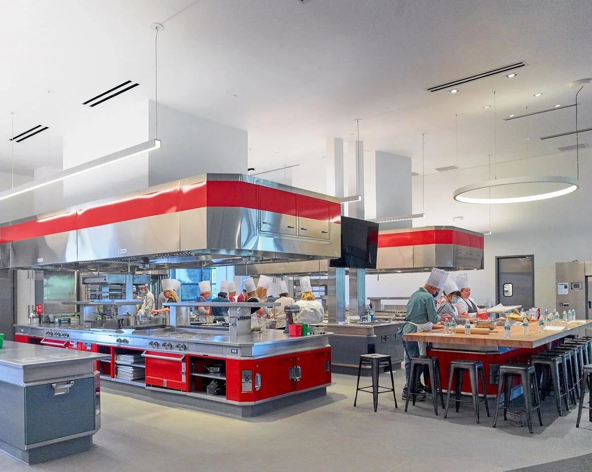 Open commercial teaching kitchen with red hoods at the Culinary Institute of America