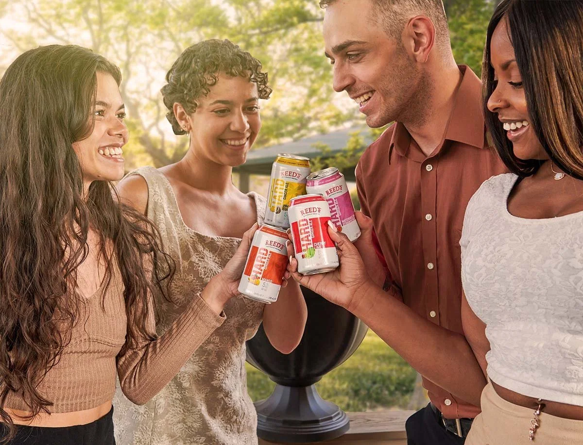 lifestyle image with models holding cans of cpg drink beverage doing cheers in sun happy lifestyle photo for brand