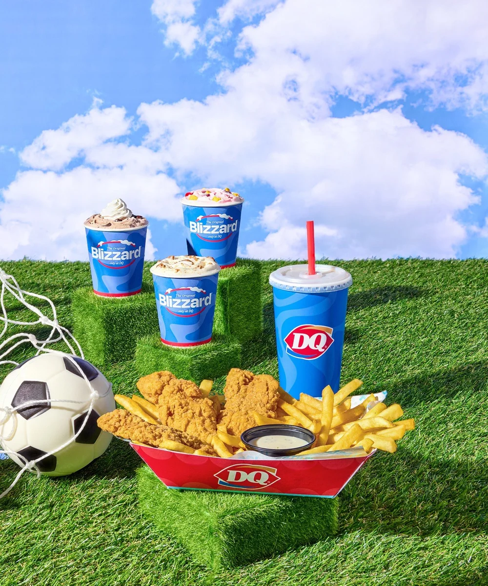 Dairy Queen chicken strip value meal and Blizzard treats on a grass soccer field set under blue sky. Campaign food photography for restaurant brands.