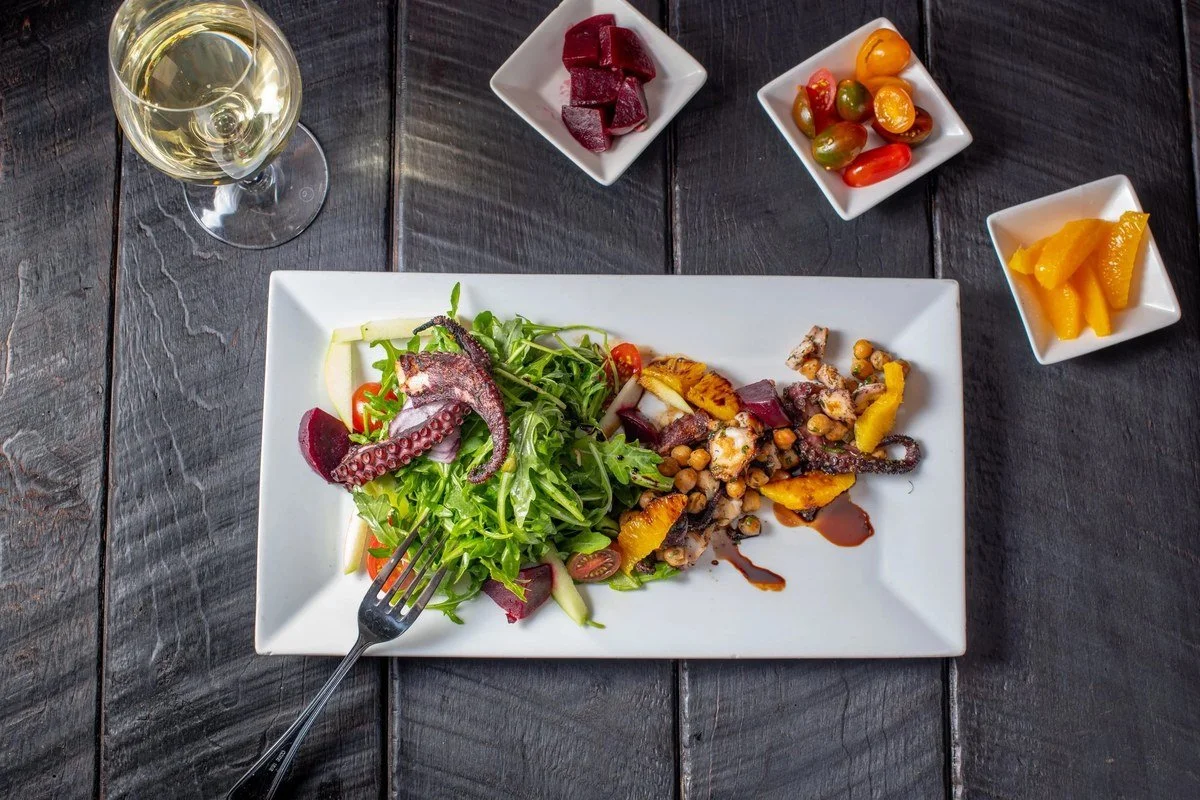 Grilled octopus salad on a rectangular plate