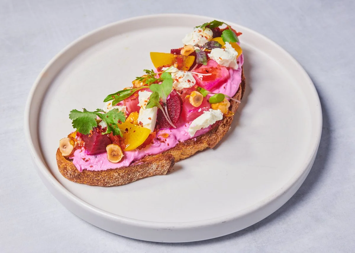 Open-faced toast with pink beet spread and microgreens