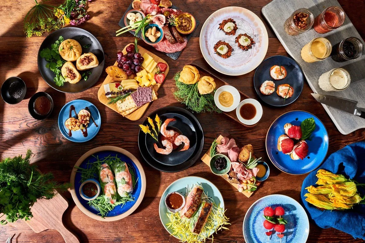Overhead spread of small plates, seafood and drinks for a restaurant menu