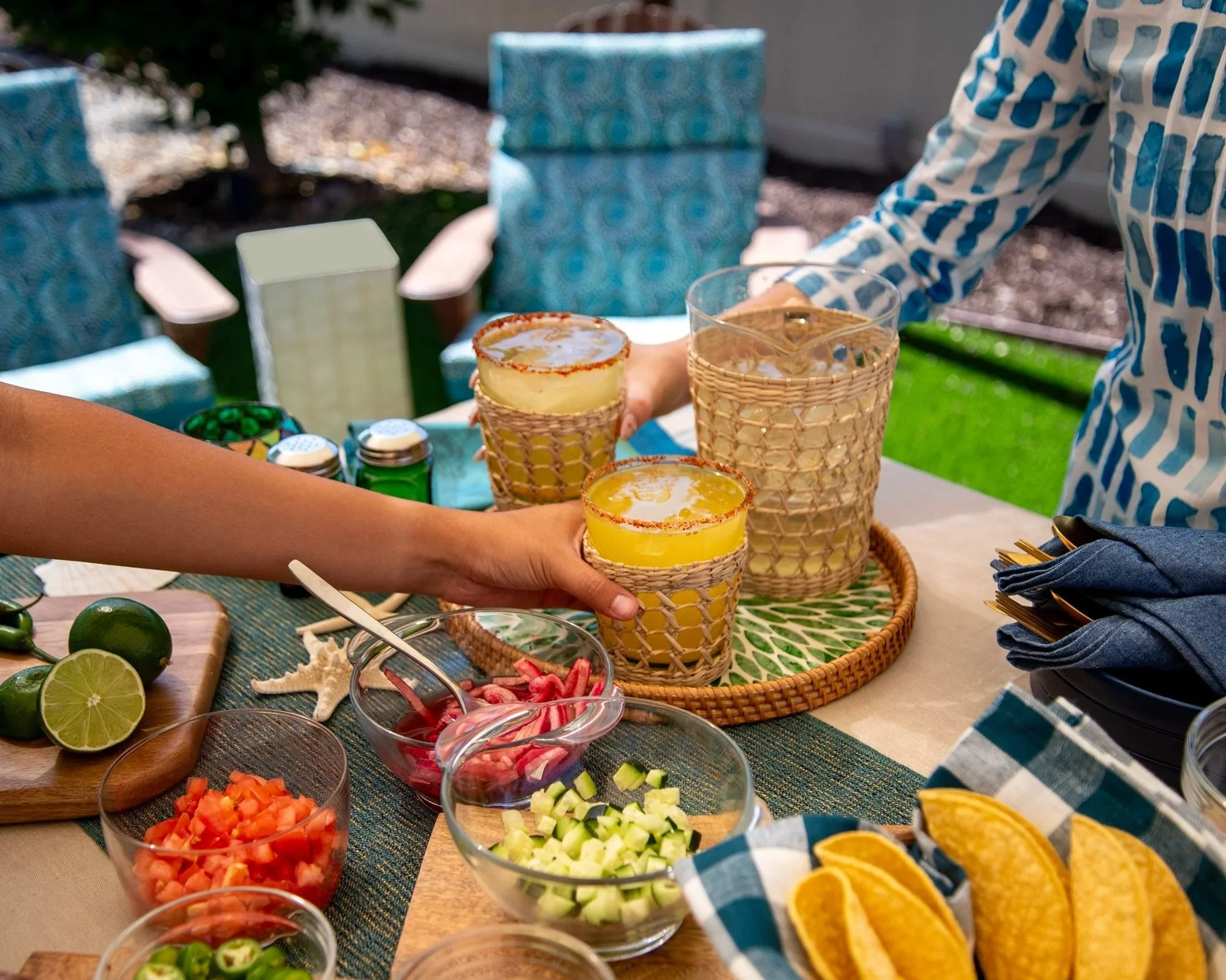 Friends reaching for tacos and drinks on a patio table, food lifestyle photography