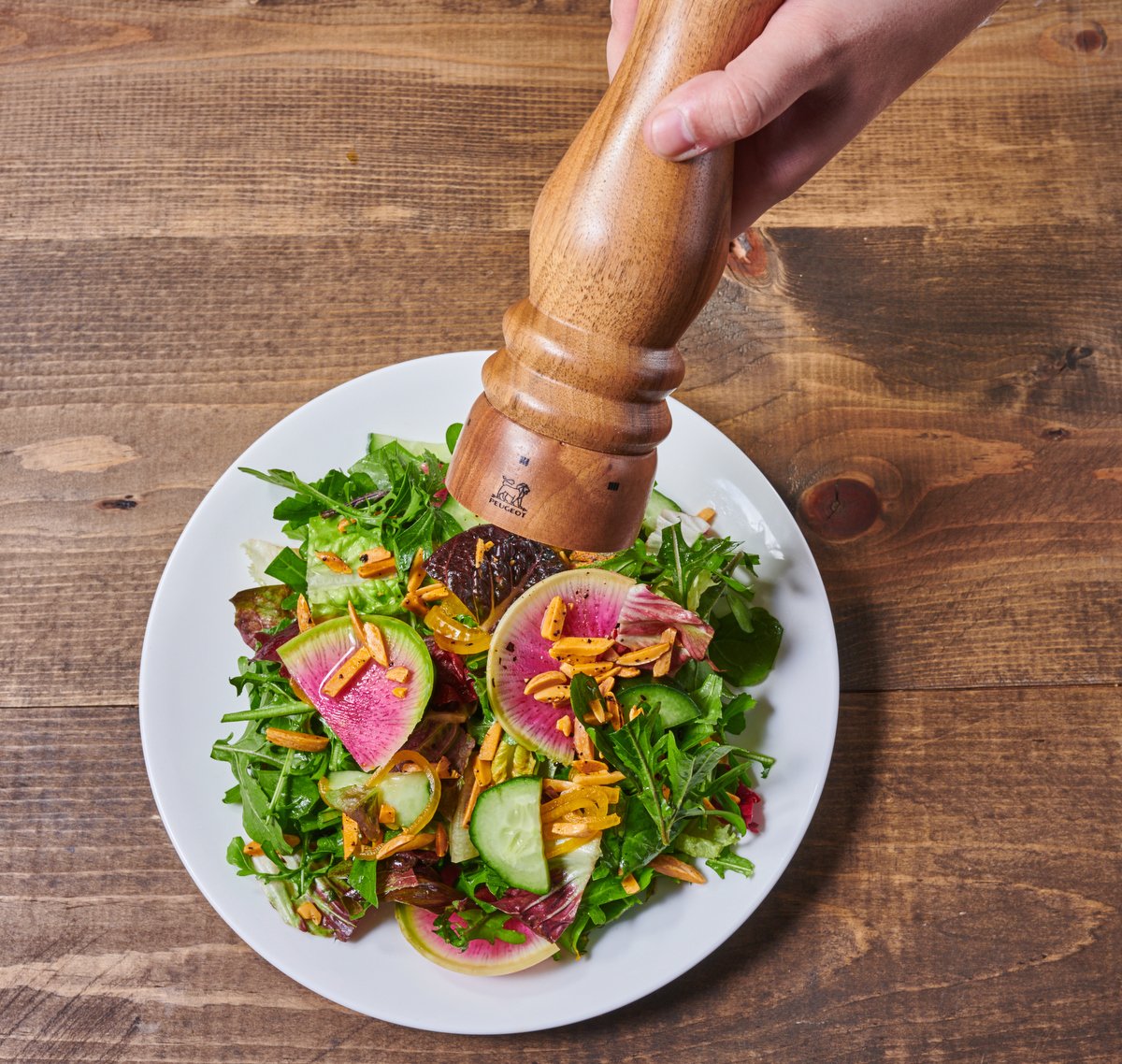 Pepper mill grinding over a fresh salad