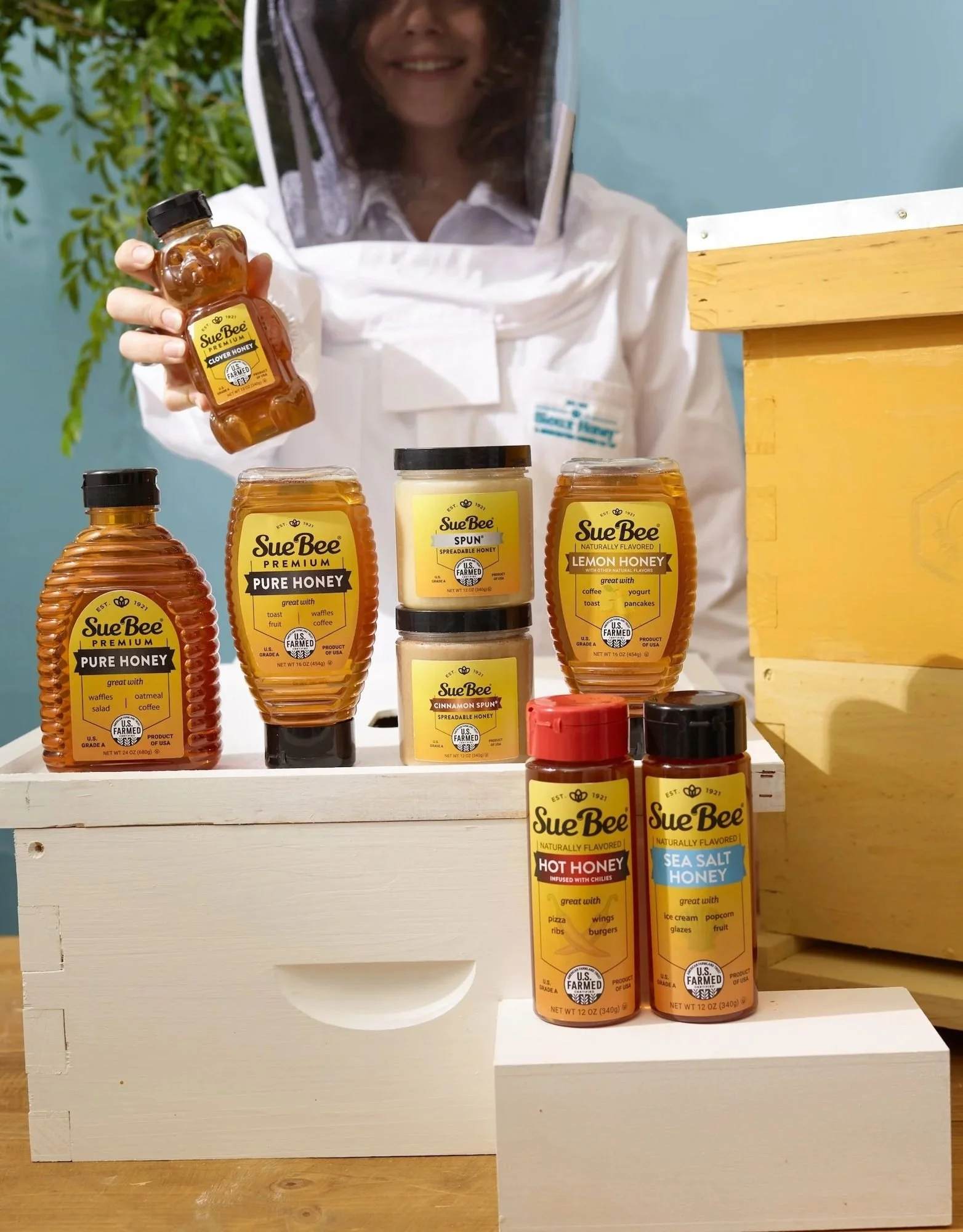 Beekeeper with Sue Bee honey bottles on a beehive box, CPG lifestyle photography