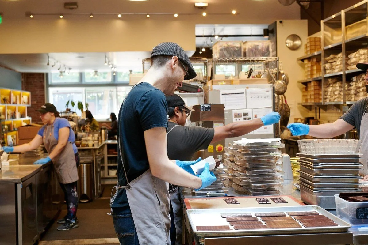 Cook plating food in an open bakery kitchen