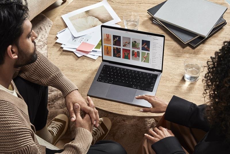 A man and a woman looking over a laptop