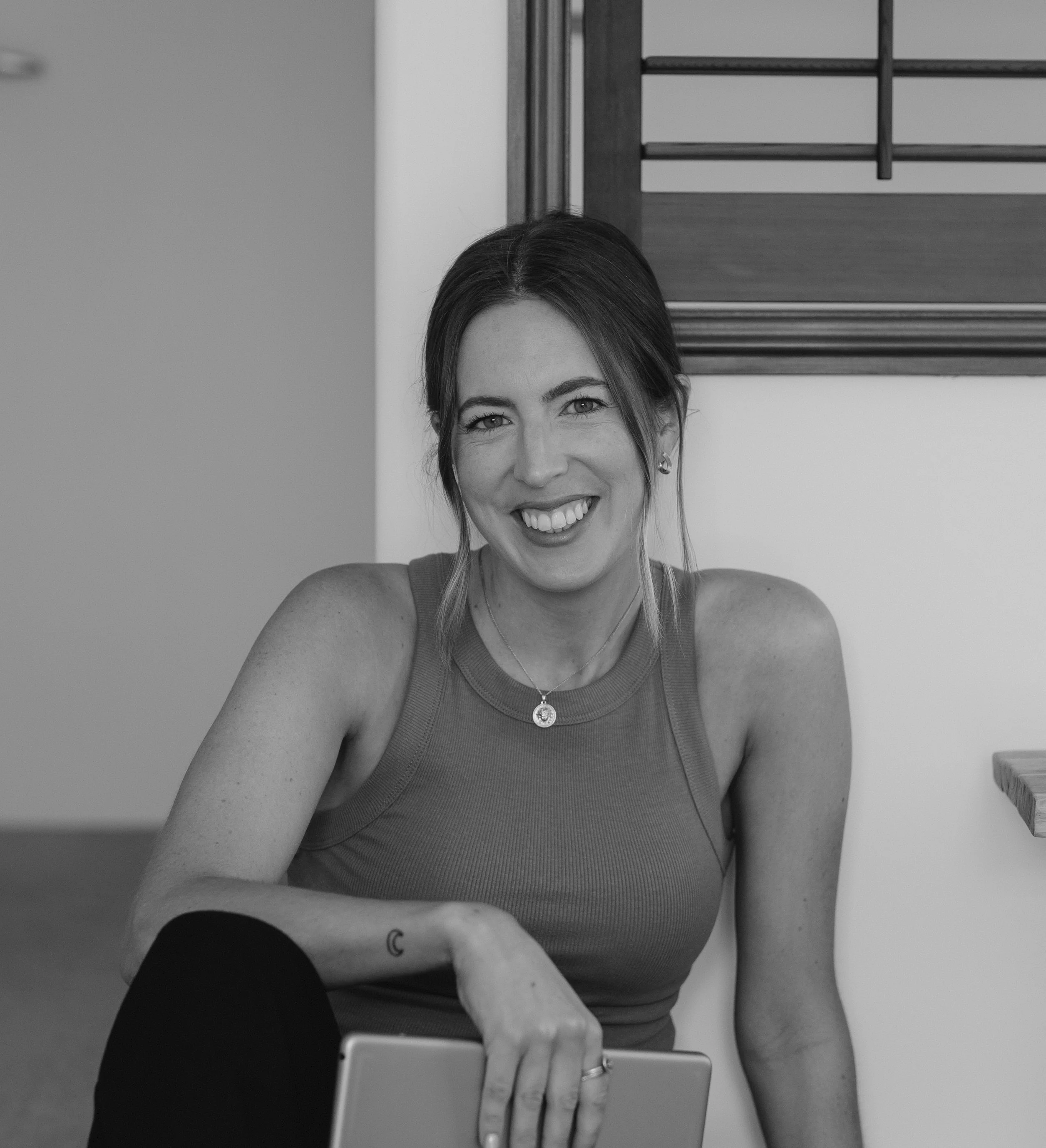 A black-and-white headshot of Erica Hartwick smiling at the camera.