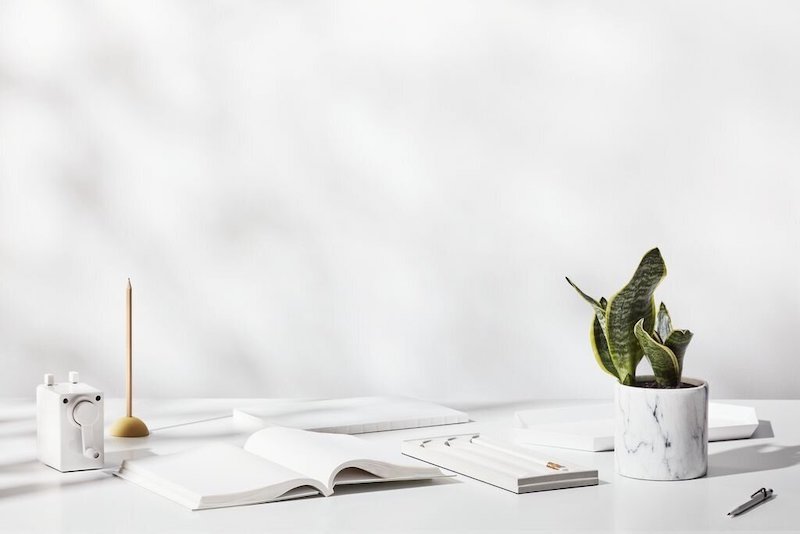 White notebooks and office objections on a white desk