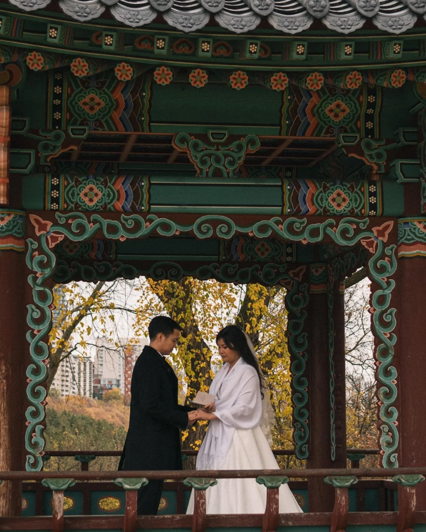 Their first touch &mdash; quiet, steady, full of emotion. 🍂
The sky stayed heavy with clouds and  the rain stopped just in time to give us the perfect moody fall backdrop. No sun, no filter, just them.
They chose to exchange private vows after  the 