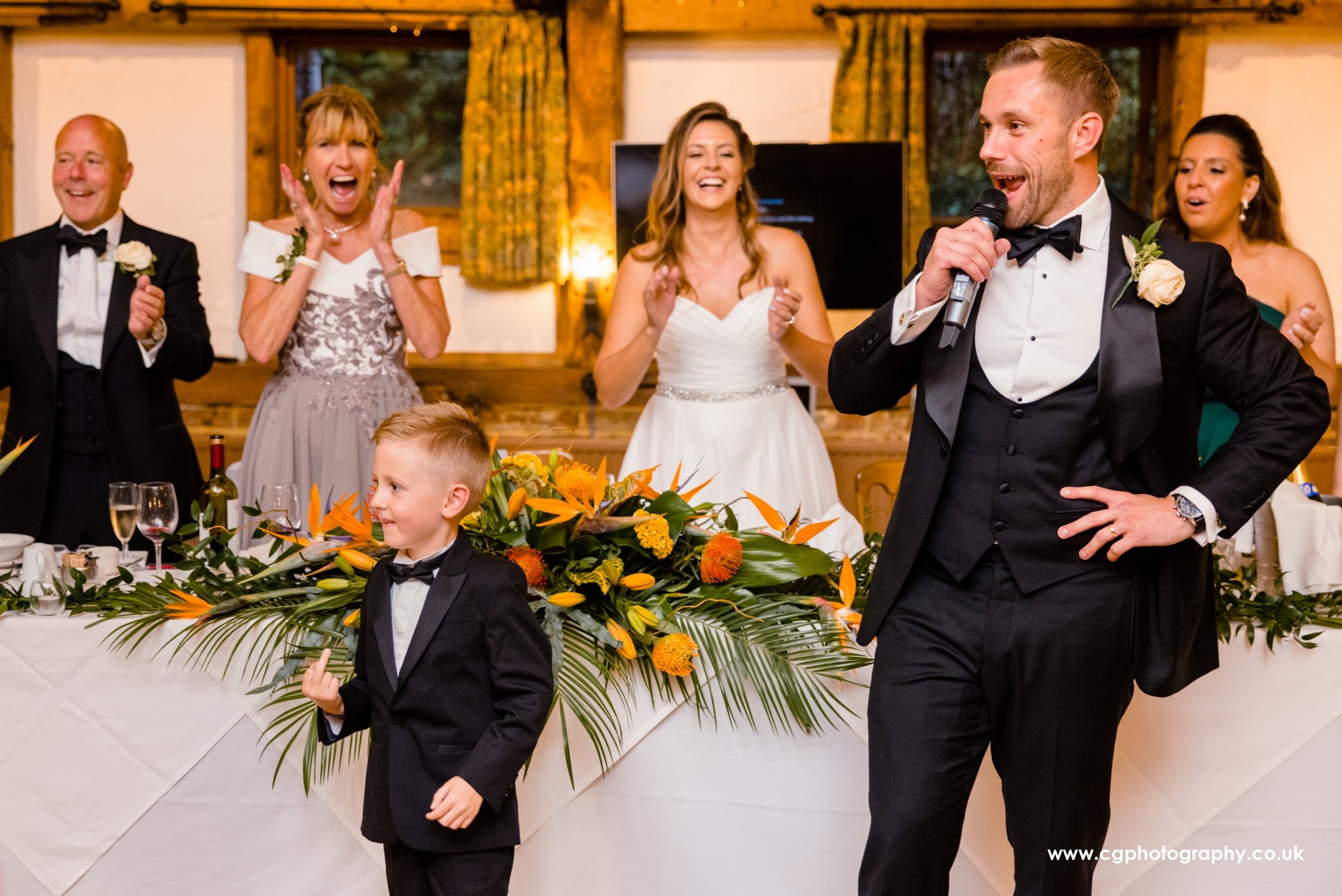 Groom's nephew showing the middle finger during funny groomsmen speech on this Brasilian wedding in Santorini