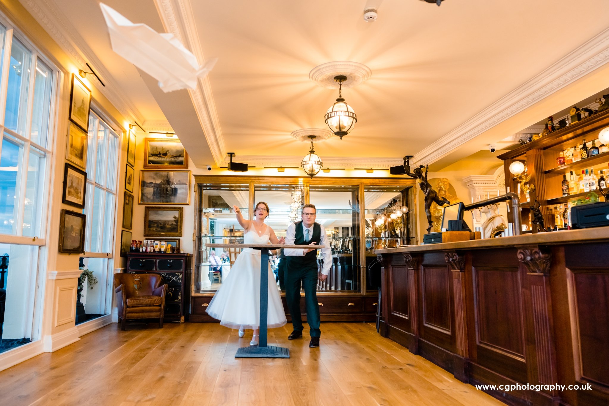 Bride and groom playing wedding night games by throwing airplane on their destination wedding in Spain.