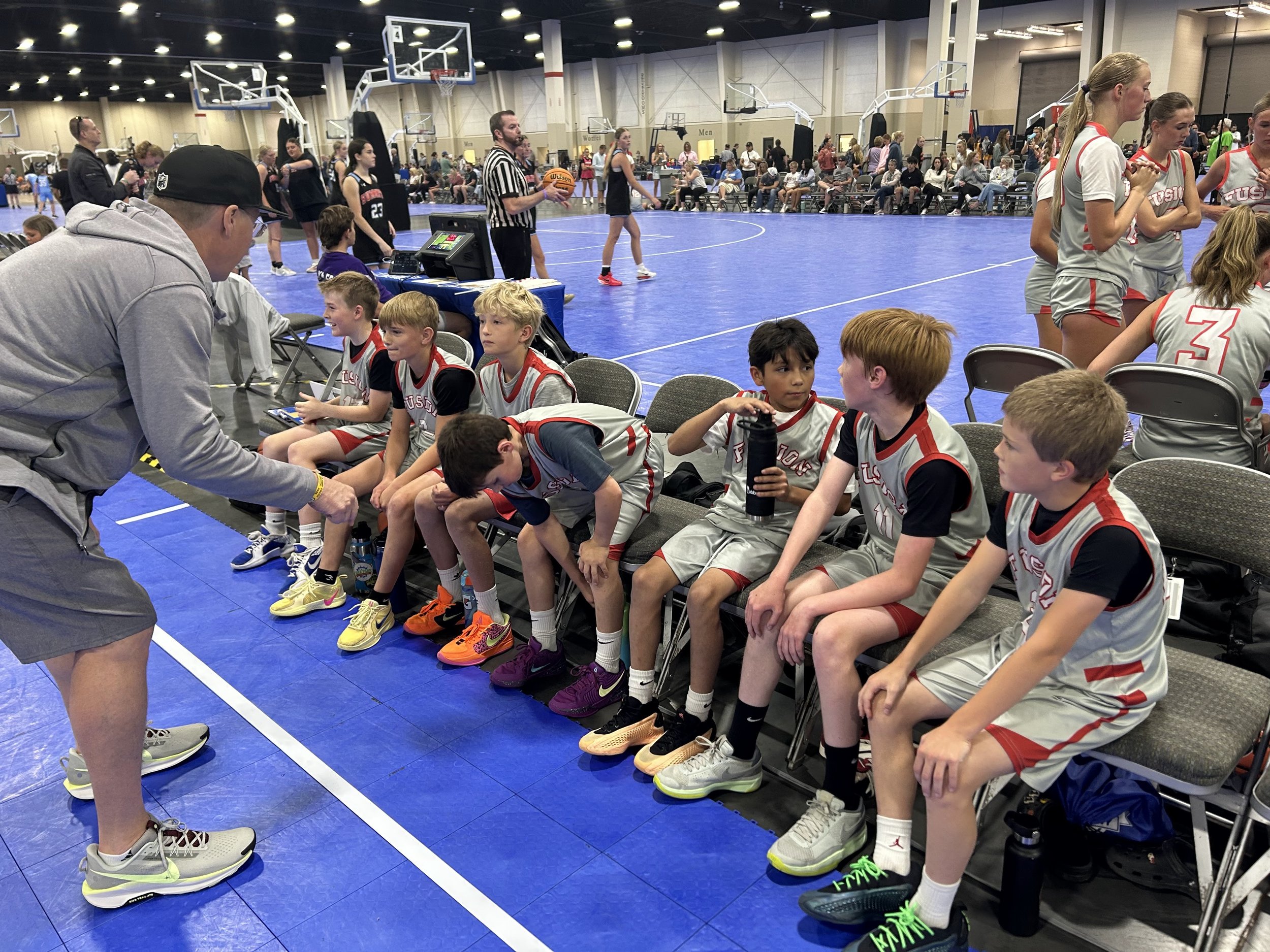 coach is working with boys on the bench