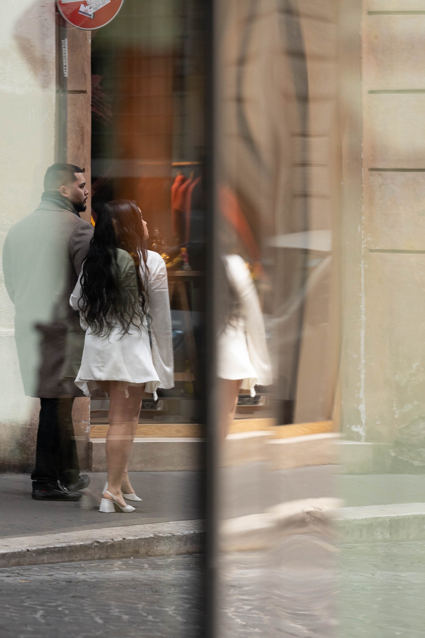 Couple reflected in a shop window on a Rome street