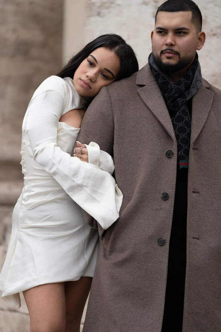 Woman resting on her partner's shoulder in a camel coat in Rome