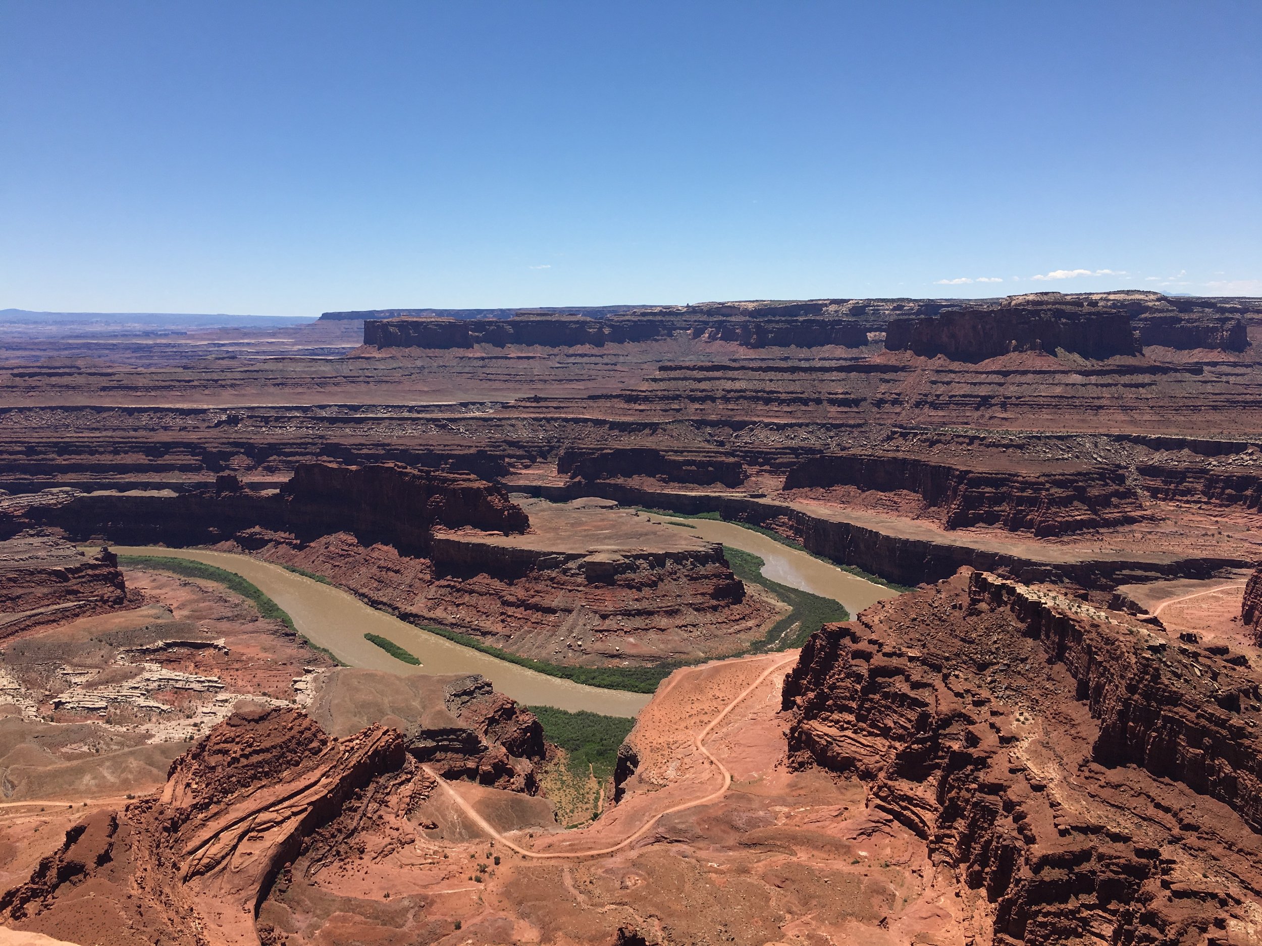 Colorado River meander in Canyonlands National Park showing layered sandstone cliffs and desert landscape.