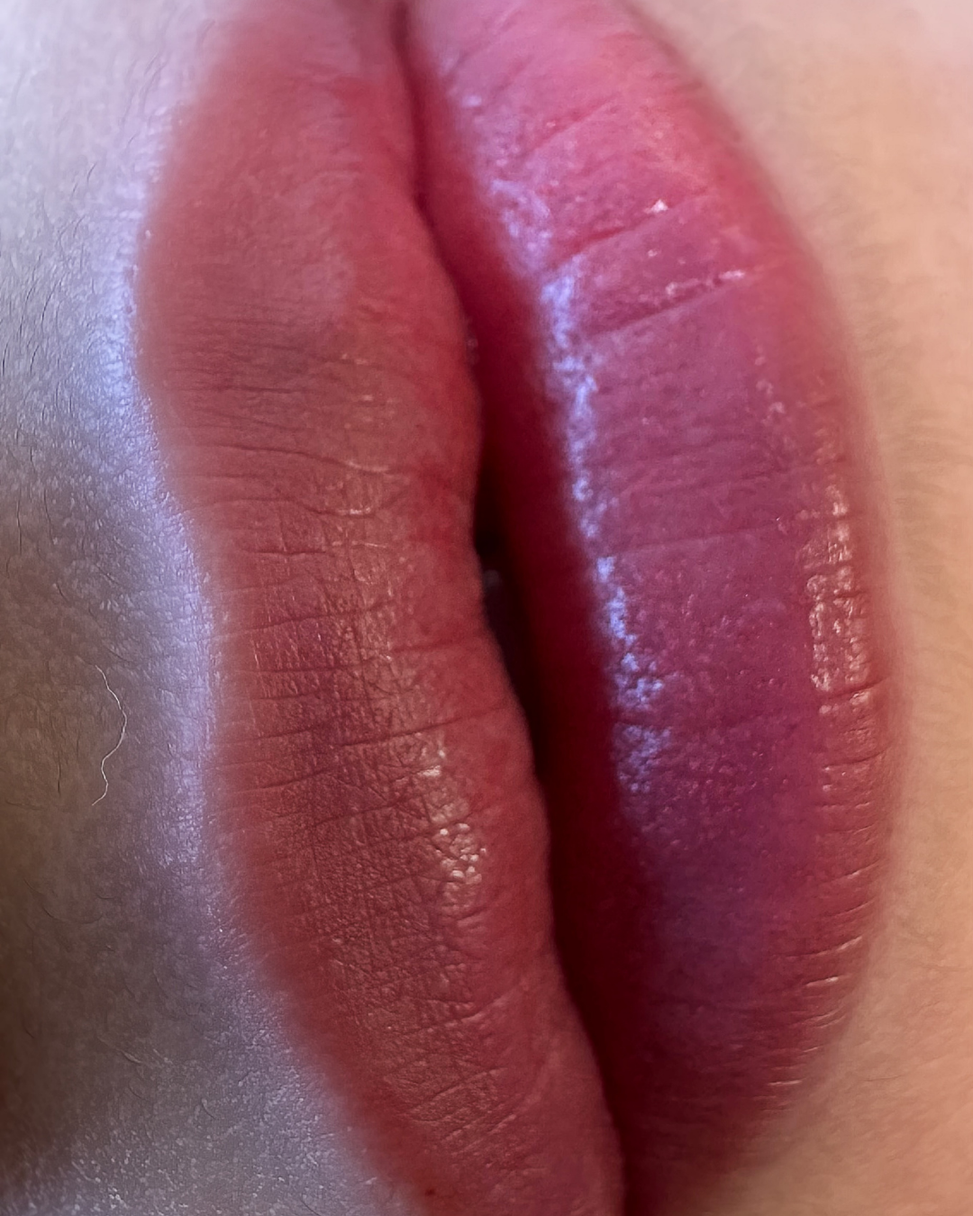 Close-up of lips with reddish lipstick.