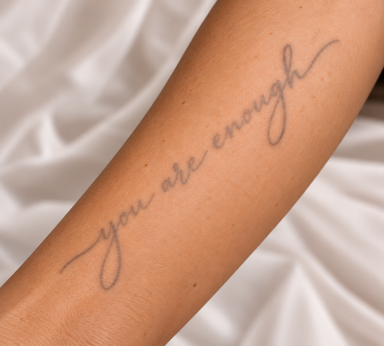 Faded script tattoo