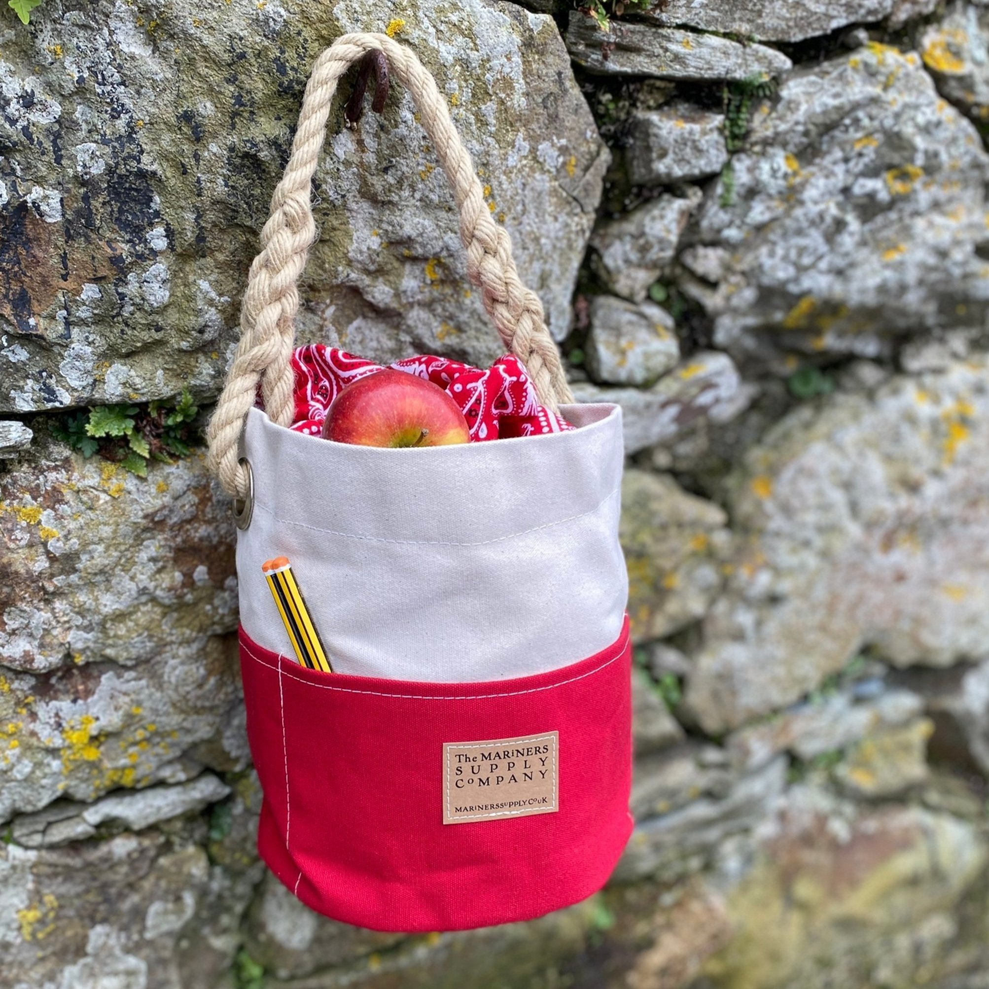 Nautical ditty bag in red and cream traditional canvas with rope handle.