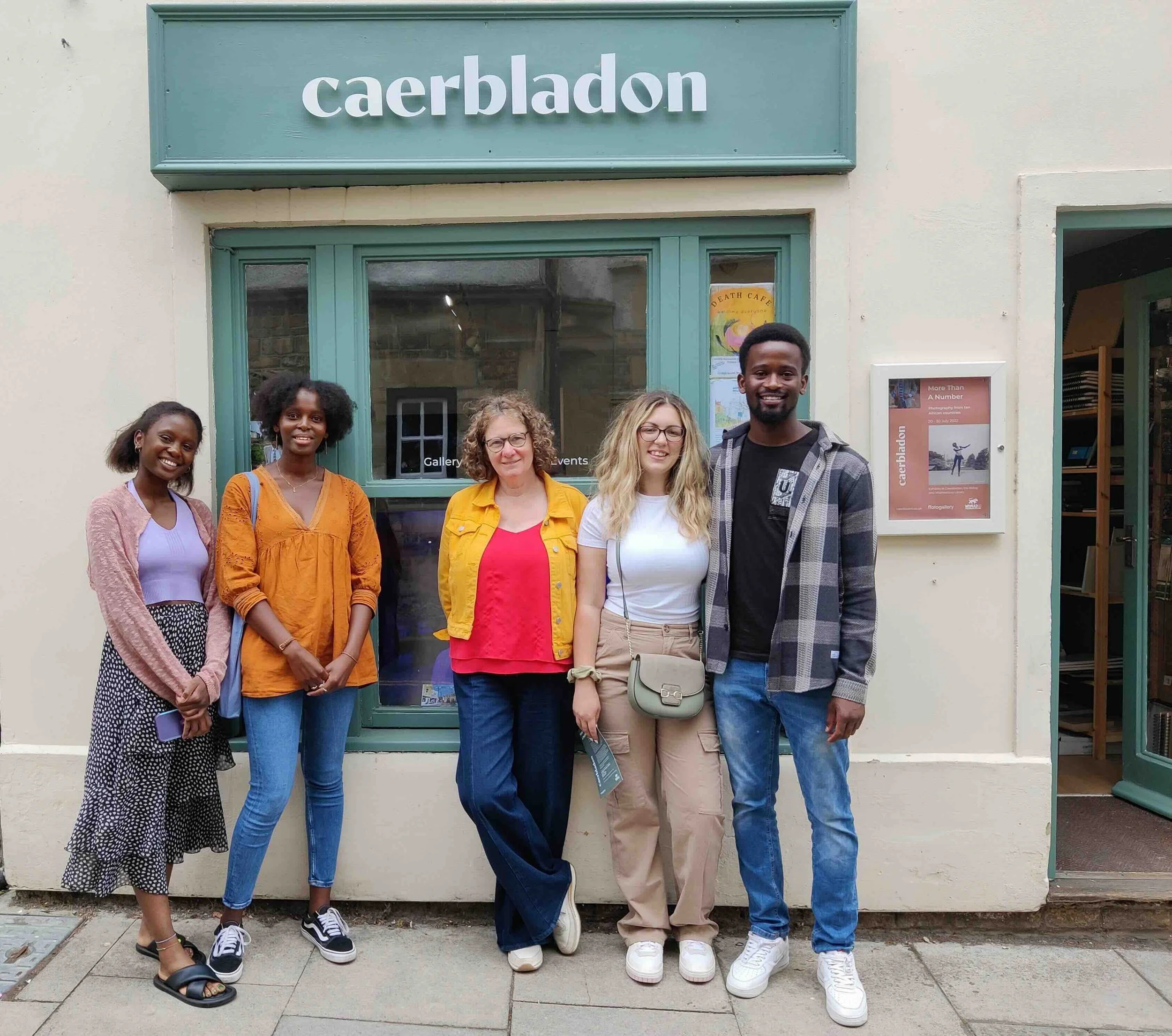 Gallery exhibitors standing in front of a building with a sign that reads 'caerbladon.'