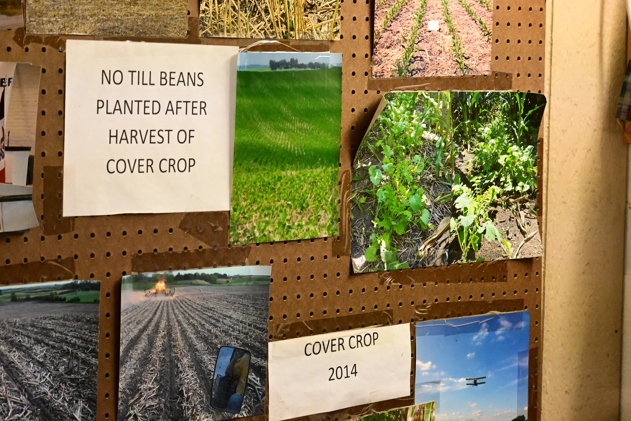  Bulletin board of photos of different conservation practices implemented on the farm, including no-till soybeans planted after the harvest of cover crop and cover crop seeding with an airplane in 2014. 