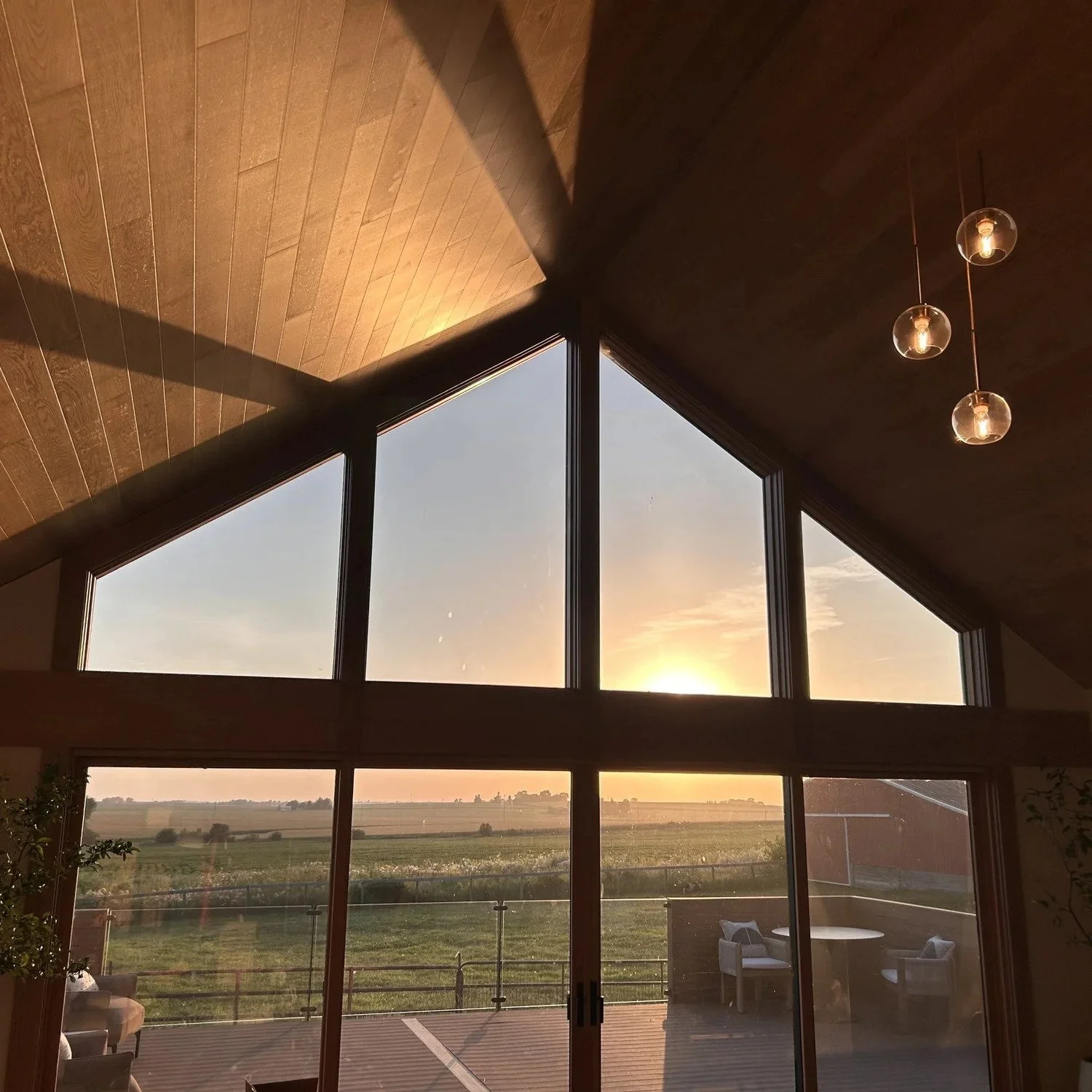  View of sunset from inside a building with tall glass windows 