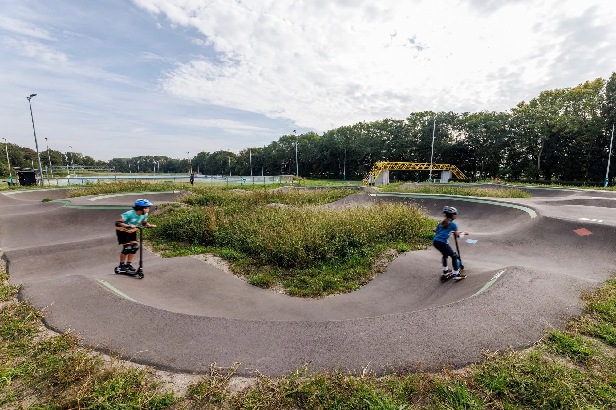 Twee rijders op de asfalt pumptrack in Rotterdam Noordrand