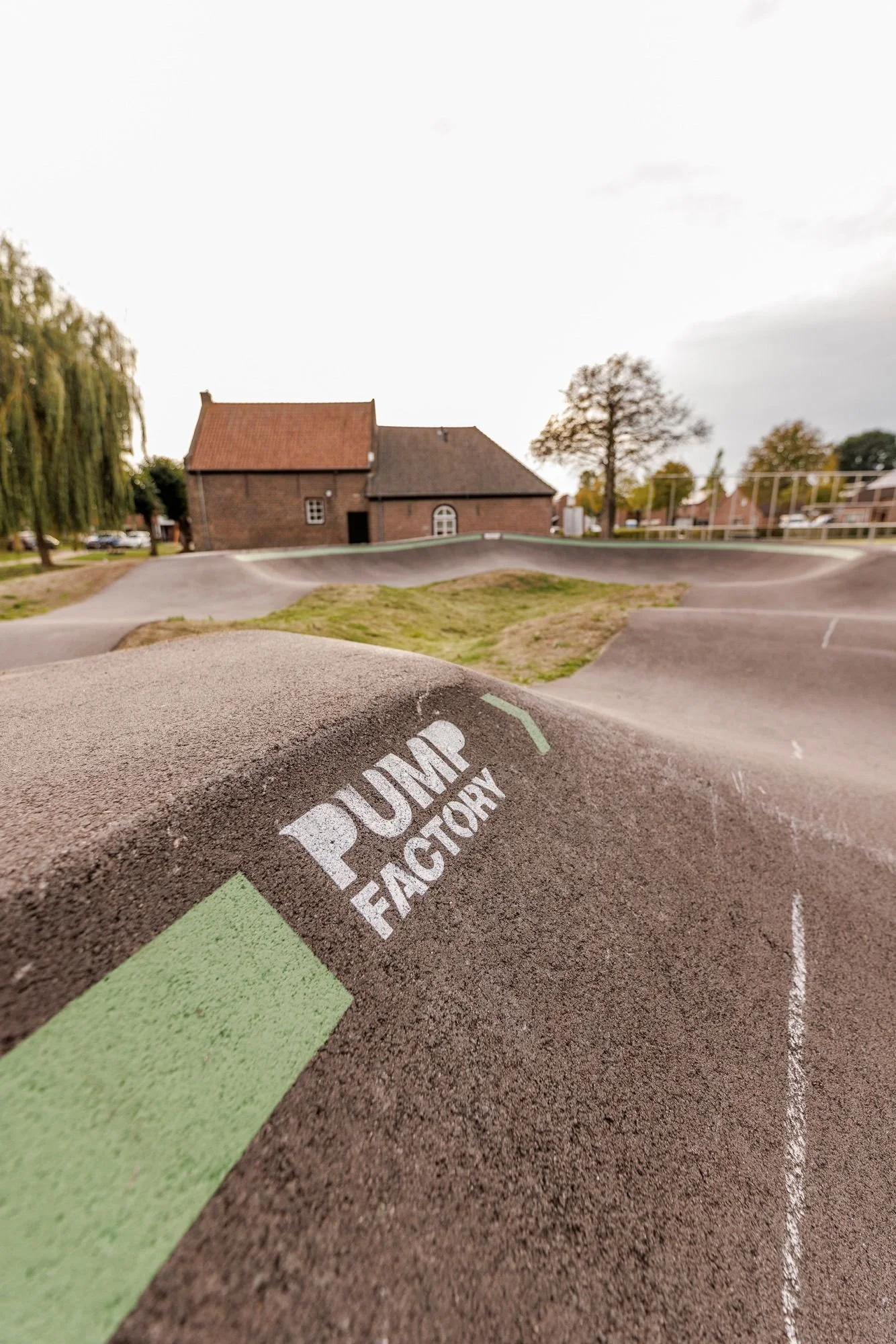 Pump Factory-logo op het asfalt van pumptrack Oostrum
