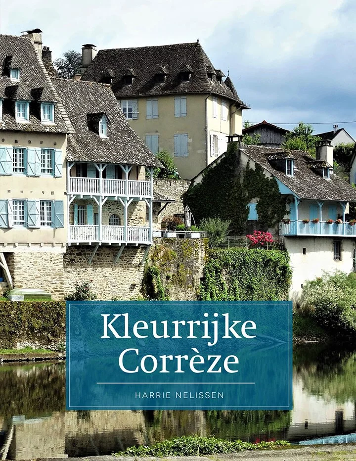 Boekcover van 'Kleurrijke Corrèze' door Harrie Nelissen, met een afbeelding van charmante huizen aan een rivier in Corrèze, Frankrijk.