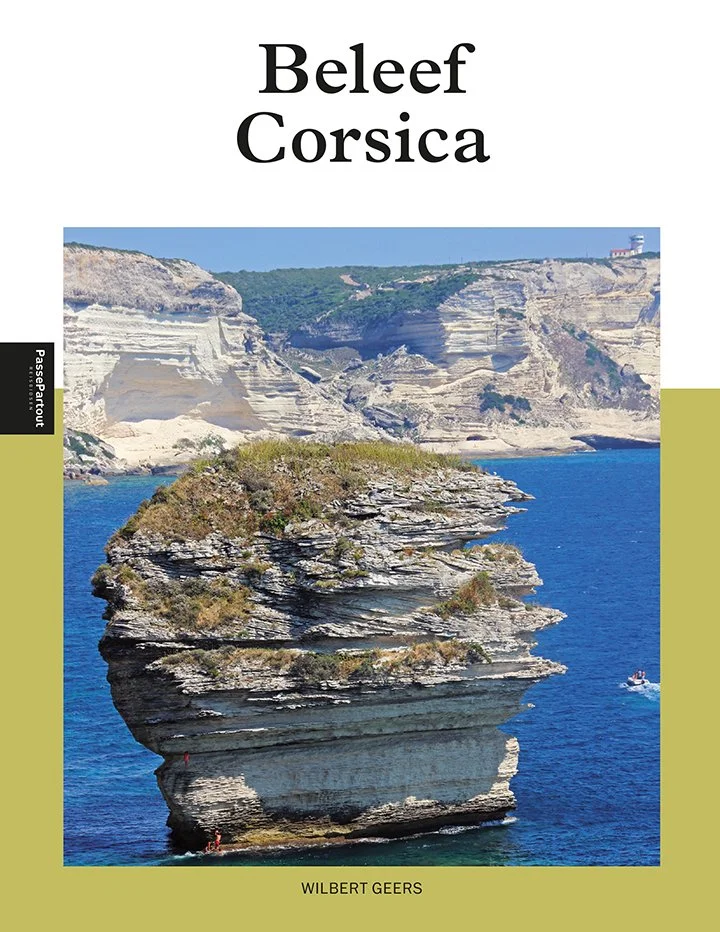 Boekomslag met titel 'Beleef Corsica', een foto van een rotsformatie in de zee met kliffen op de achtergrond, auteur Wilbert Geers.